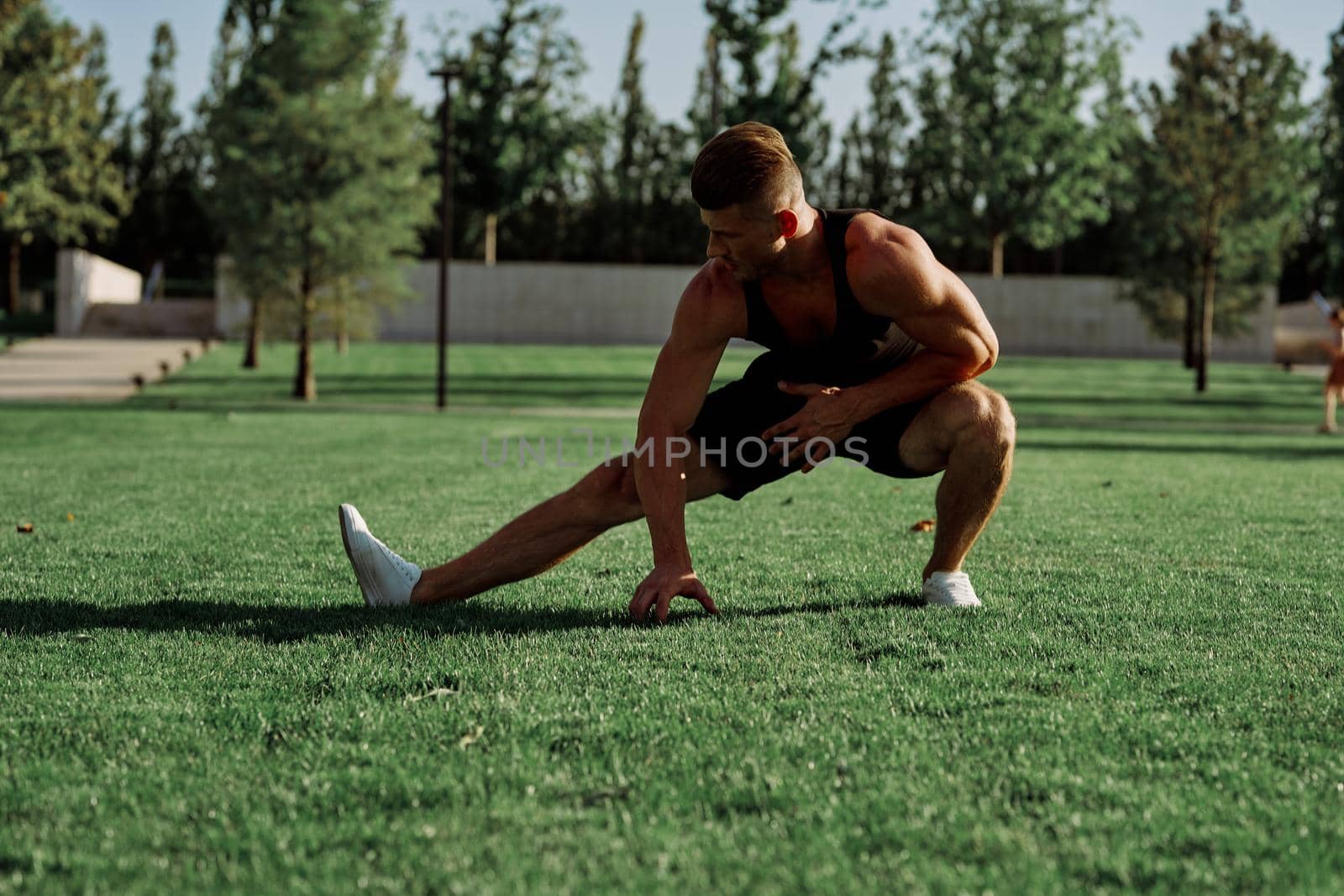 sports man doing exercises on the lawn in the park. High quality photo