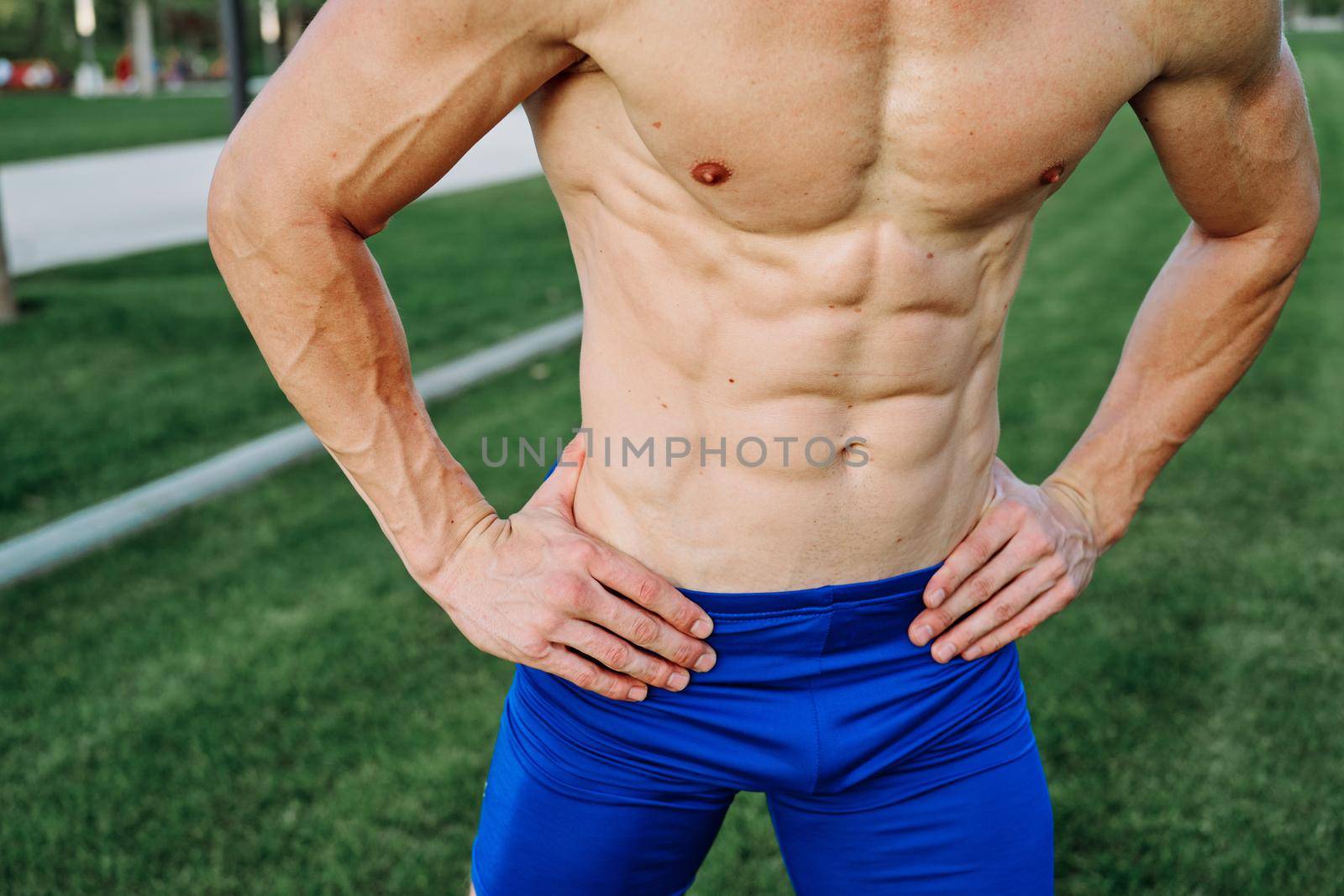 sporty man with pumped up abs in the park while workout exercise lifestyle. High quality photo