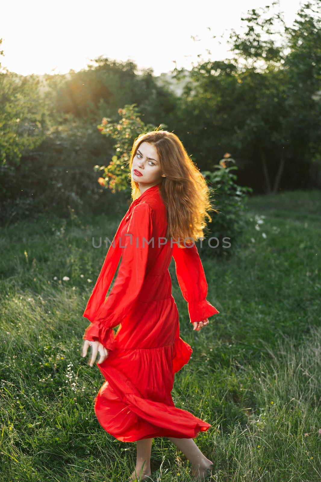 attractive woman in red dress outdoors in freedom field by Vichizh