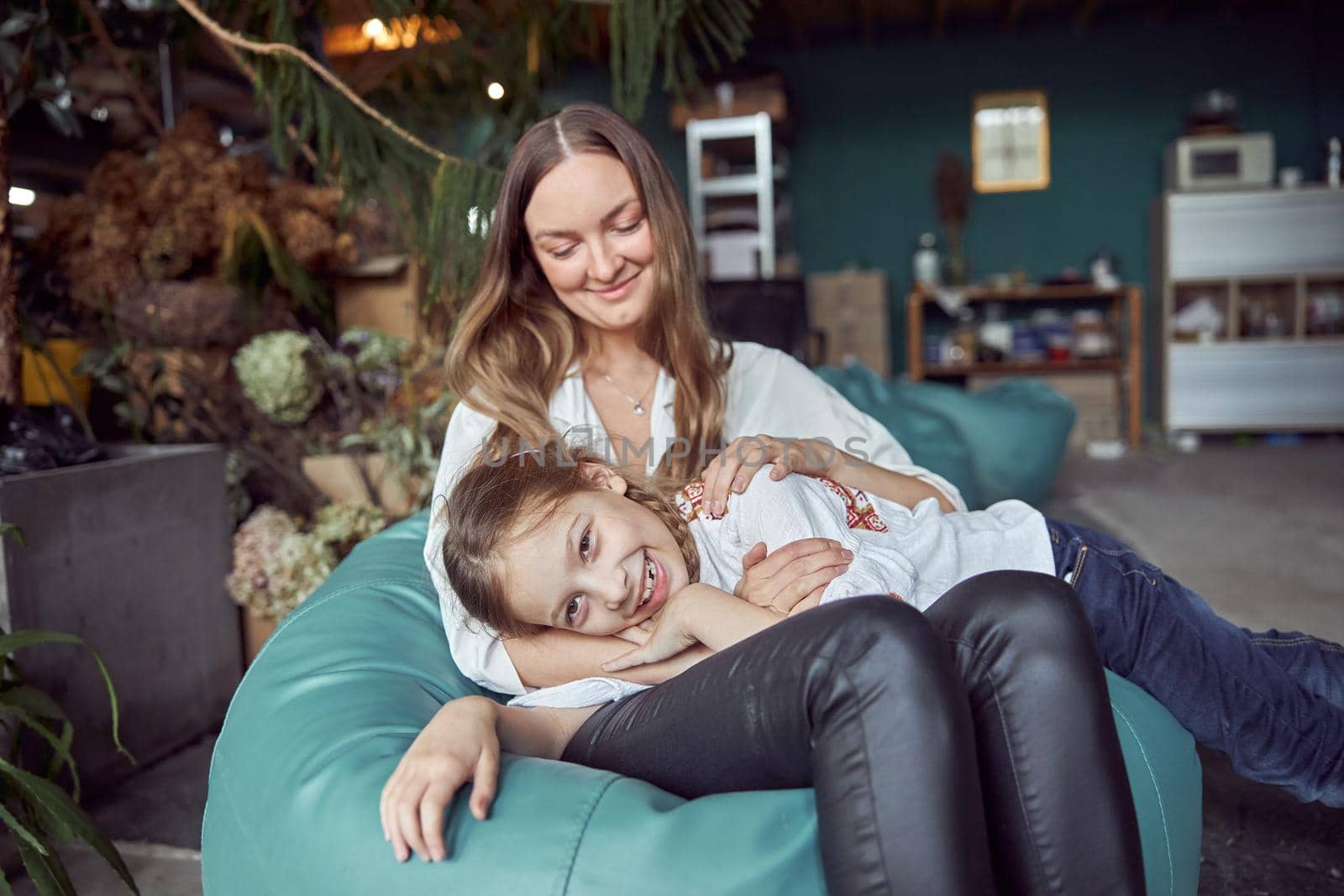 Happy caucasian mother with young beautiful cheerful daughter are having time together