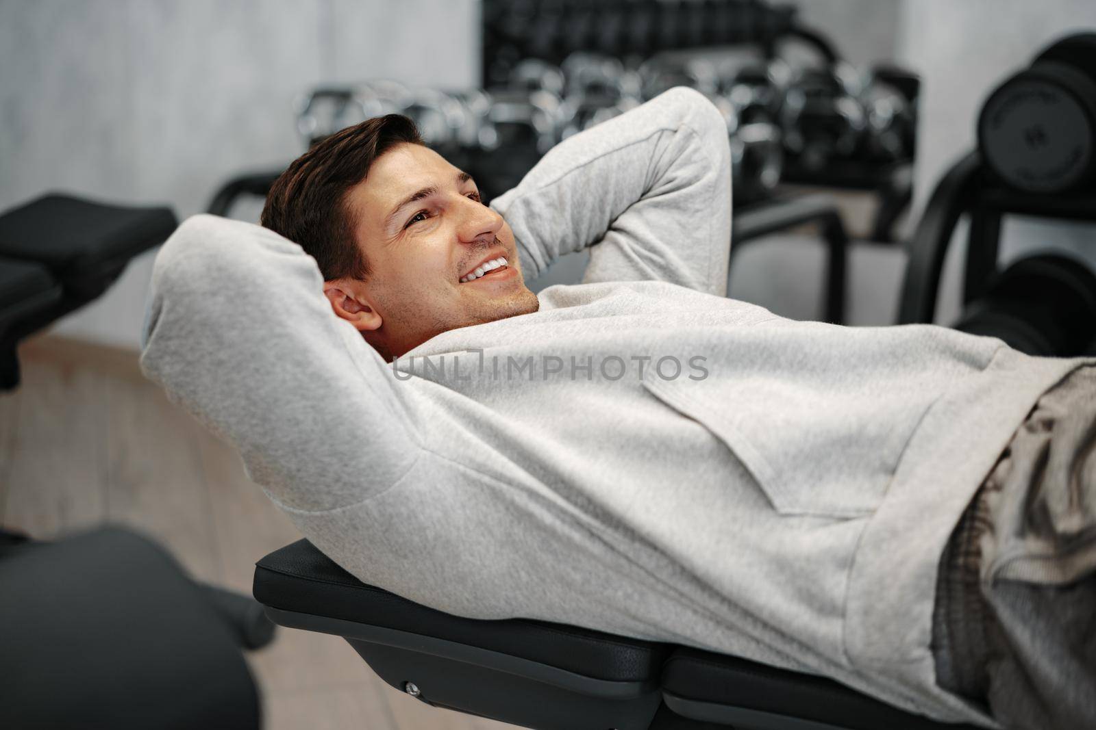 Young athlete doing abs exercises workout in modern gym, close up