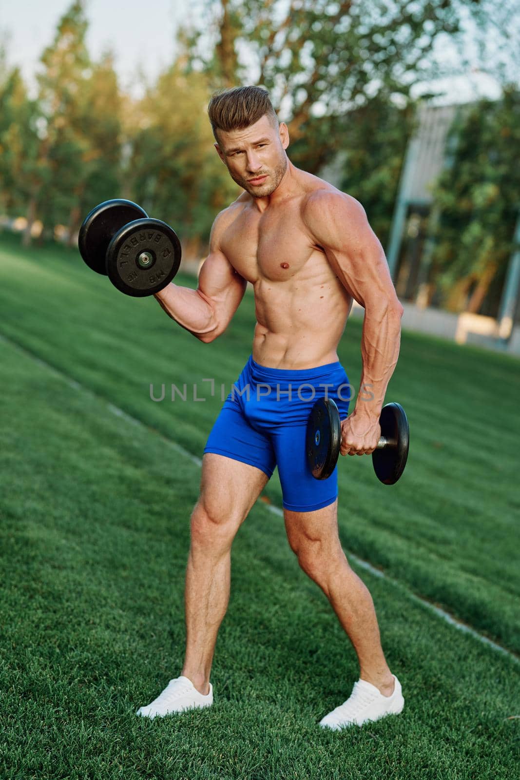 sporty man with pumped up body in park workout exercise. High quality photo
