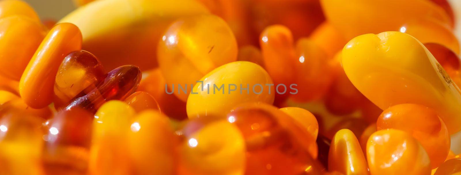 Sunny beads of fire amber. Natural gemstone background, jewelry concept by Olayola