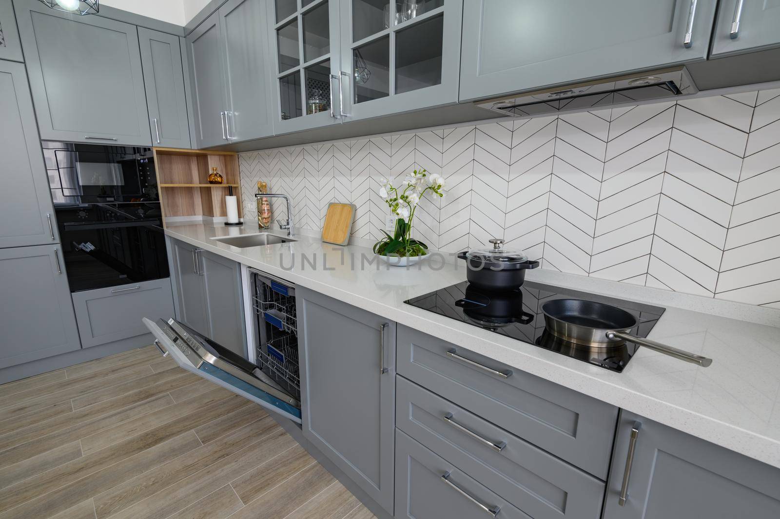 Trendy grey and white modern kitchen furniture showcase with oven's door open