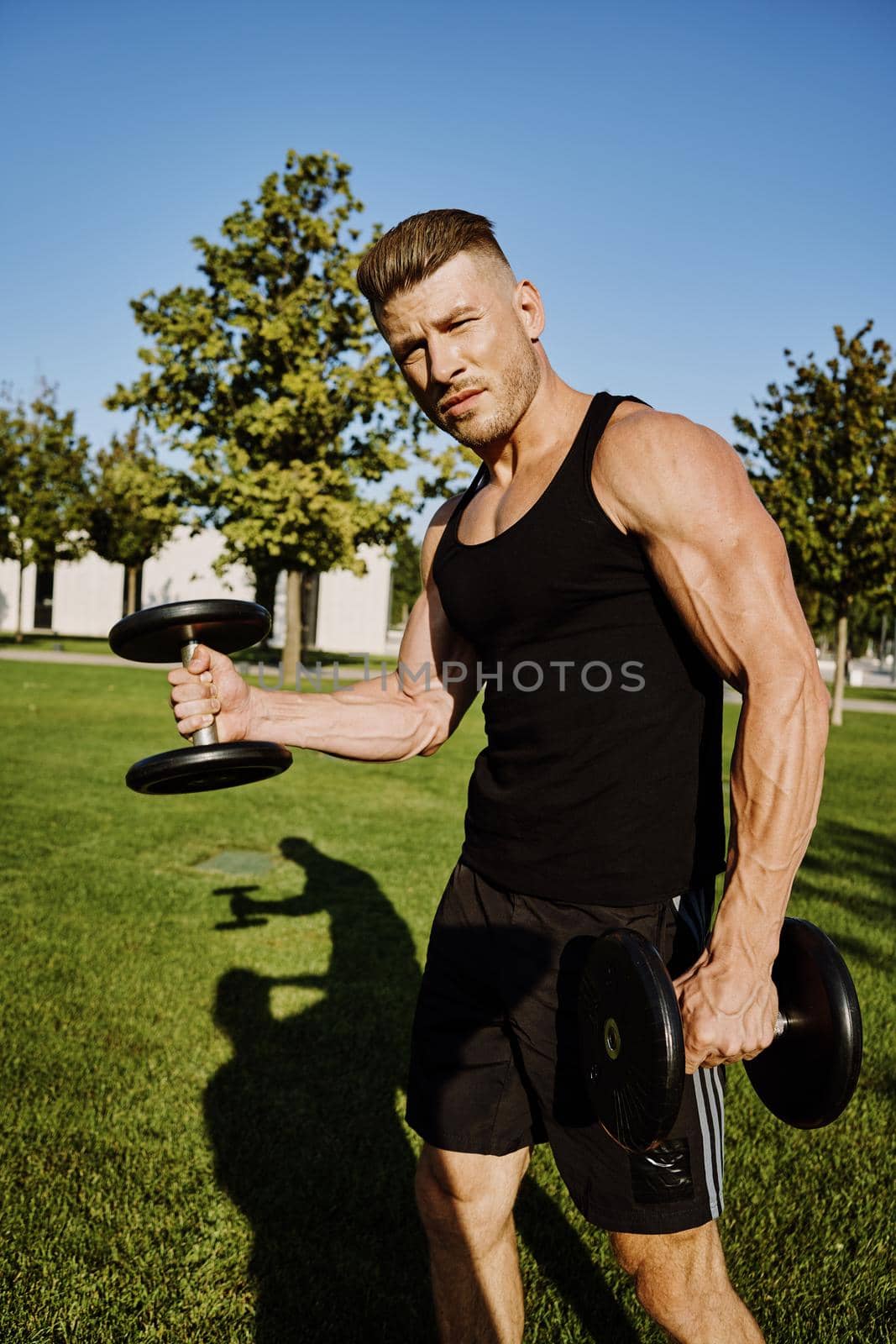 sports male park workout fitness exercise dumbbells. High quality photo