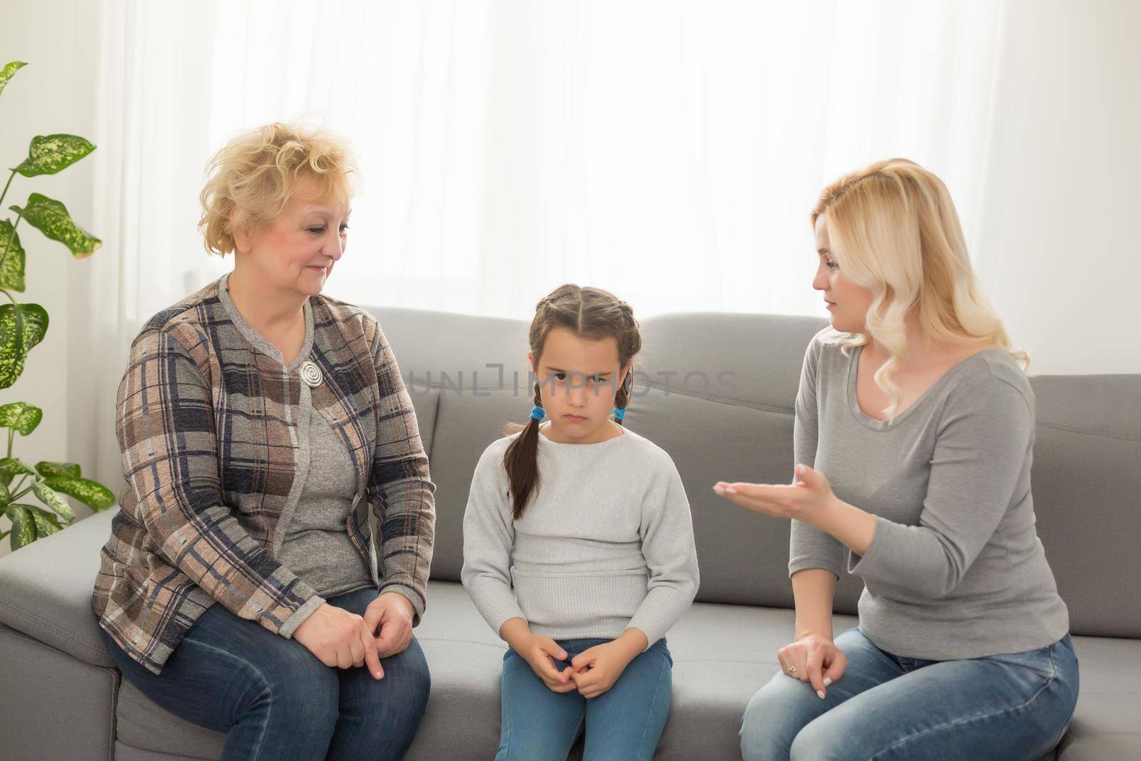 Little girl sitting at home crying while mom and granny scolding her by Andelov13