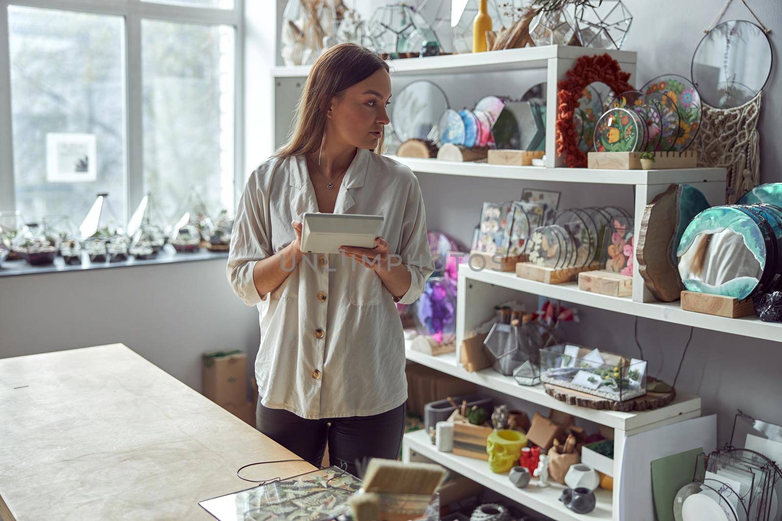 Young caucasian happy seller woman at botanic shop