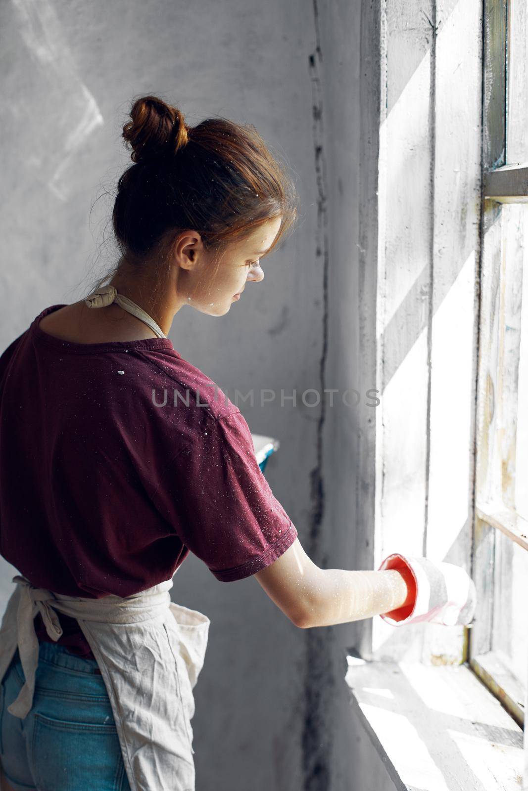 woman paints the window in the room interior renovation decoration by Vichizh