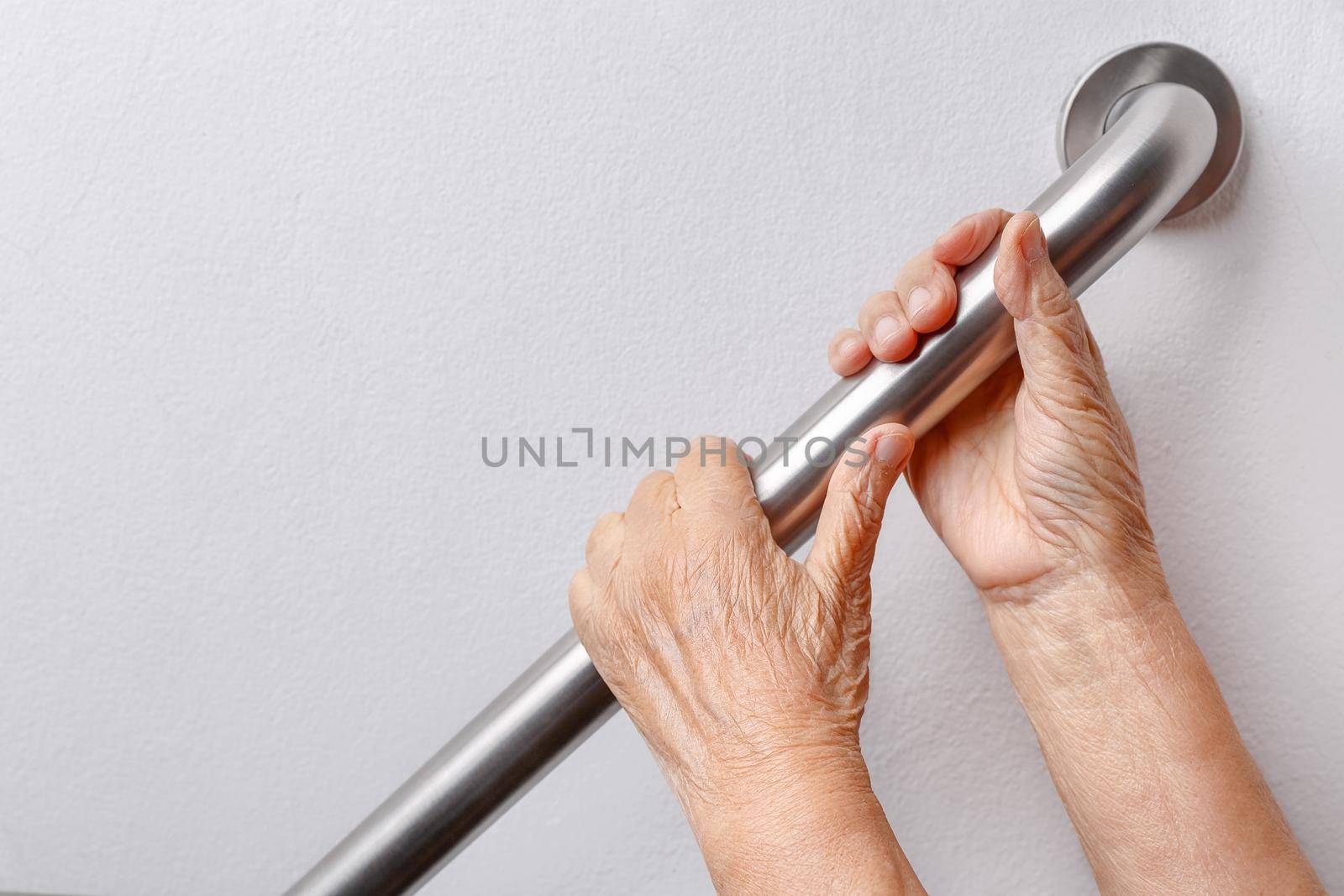 Elderly woman holding on handrail for safety walk steps by toa55