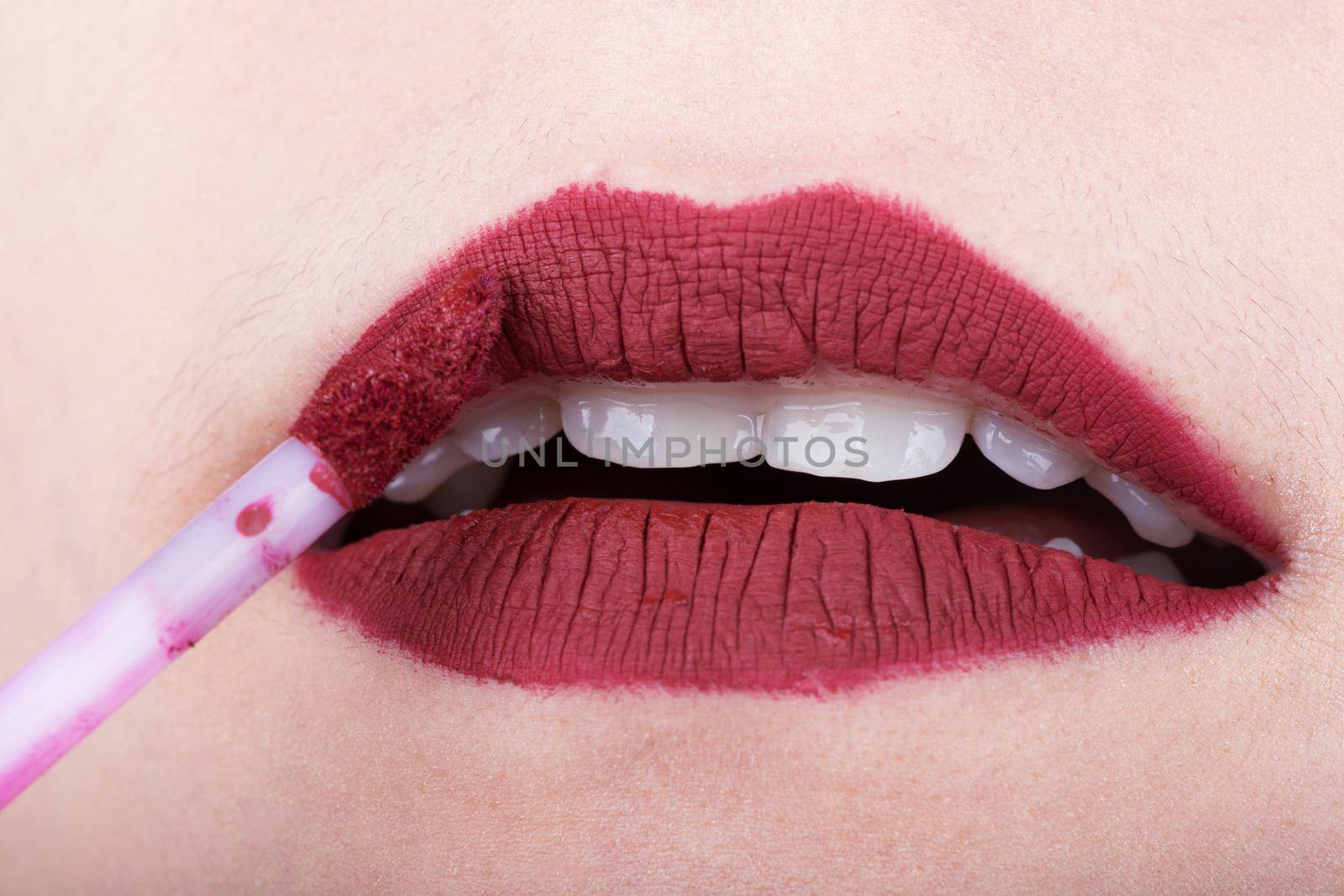 woman applying red lipstick on her lips by geargodz
