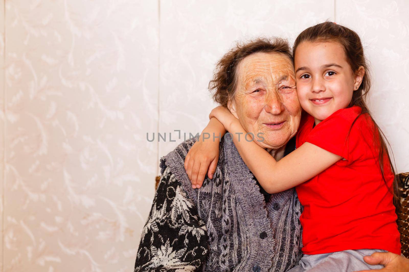 cheerful young girl taking care of an elderly woman at home by Andelov13