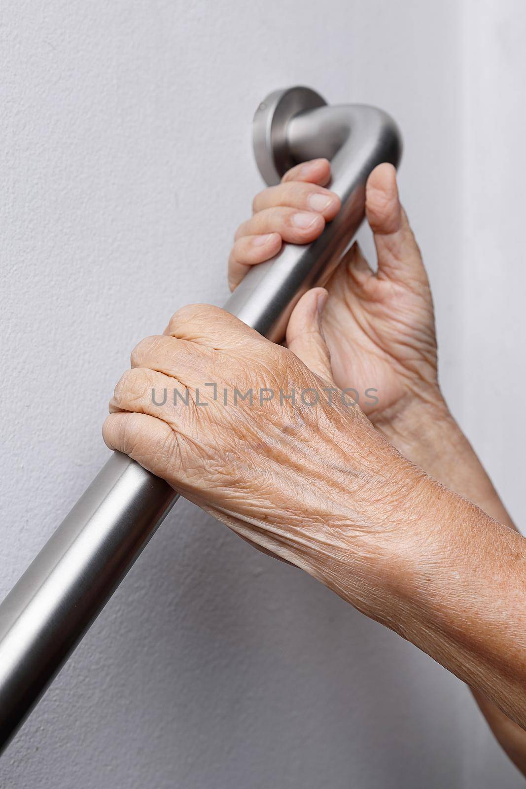 Elderly woman holding on handrail for safety walk steps by toa55