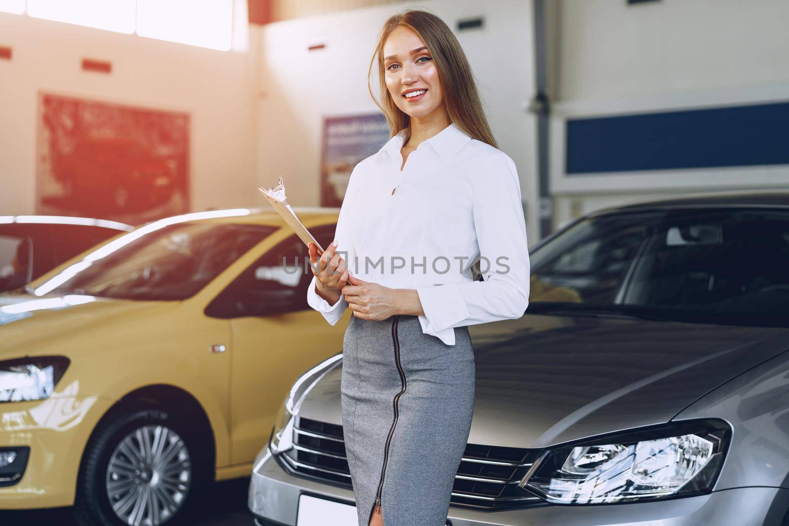 Happy beautiful young woman car dealer in showroom close up