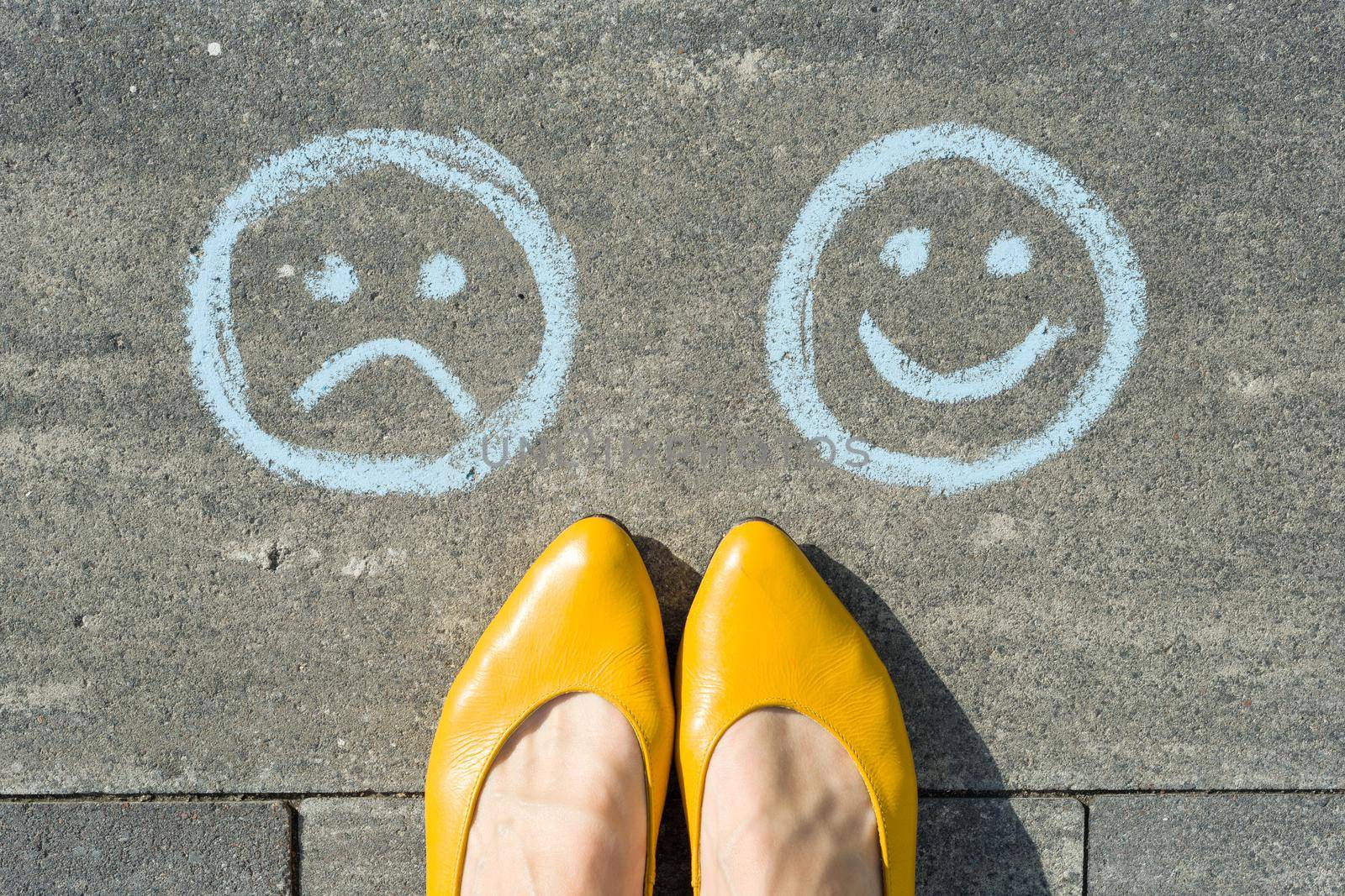 Choice - Happy Smileys or Unhappy, text on asphalt road.