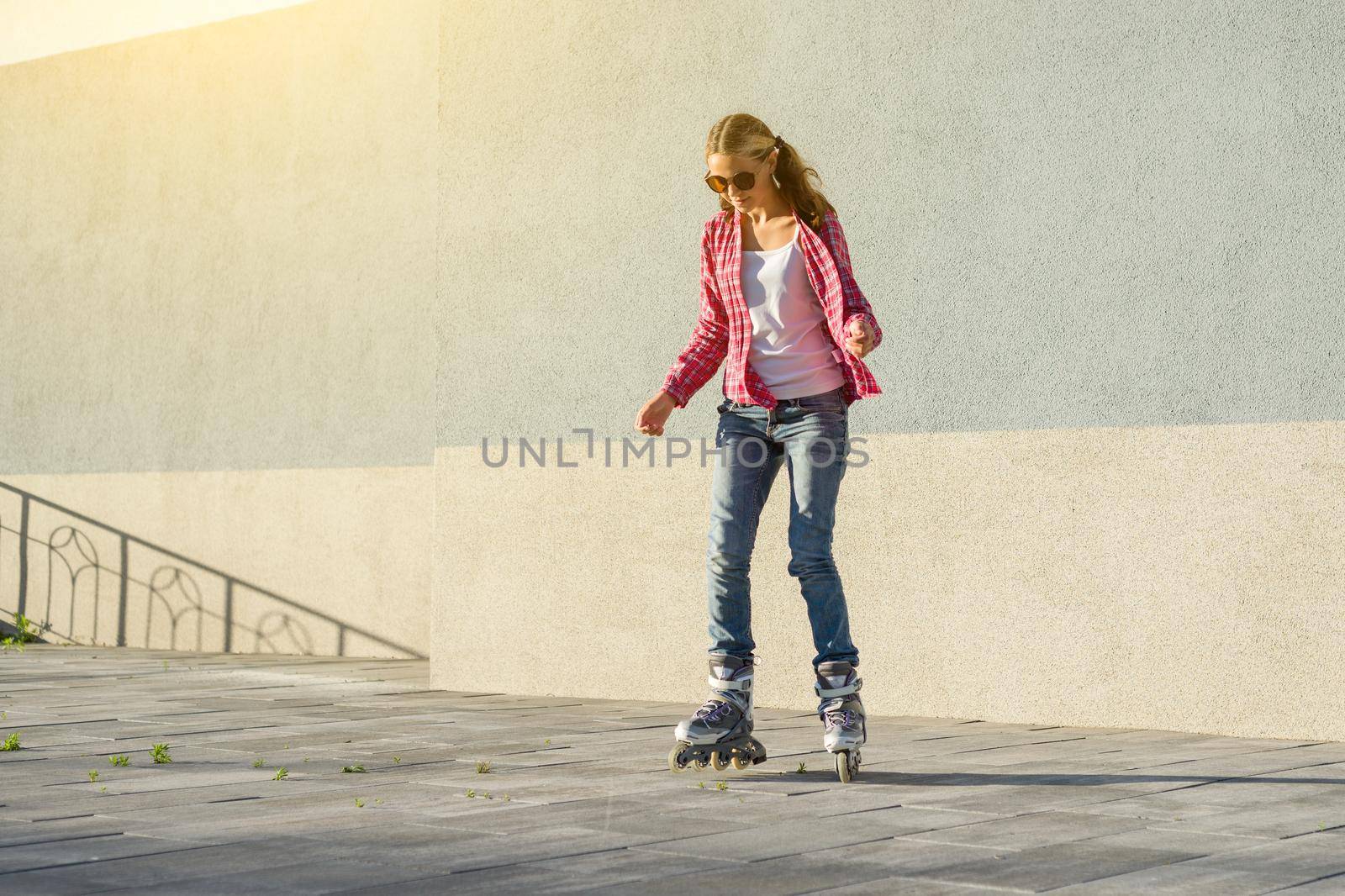 Active sports girl teen in roller skates on the urban background