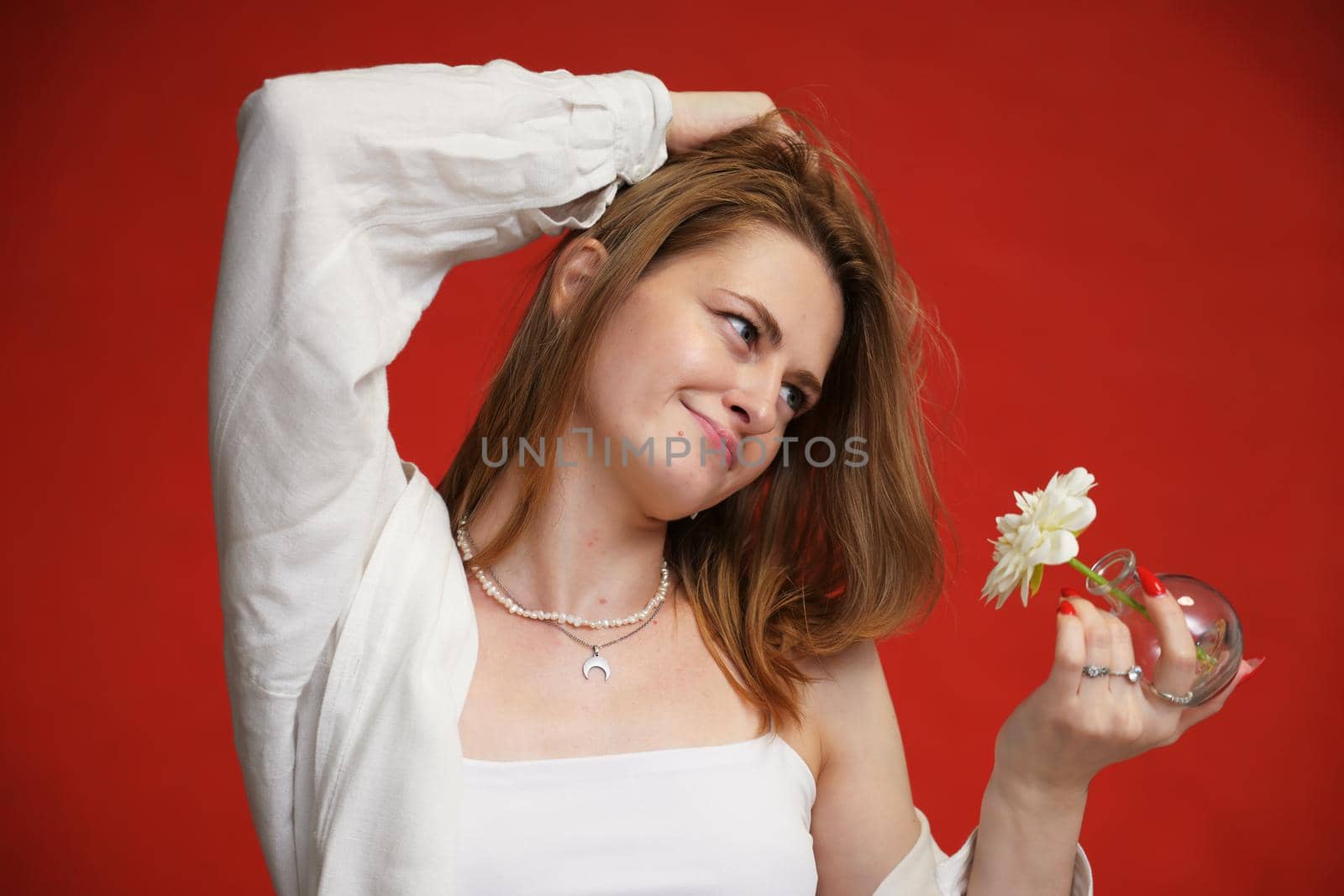 Portrait of happiness girl with a flower in her hand studio on a red background