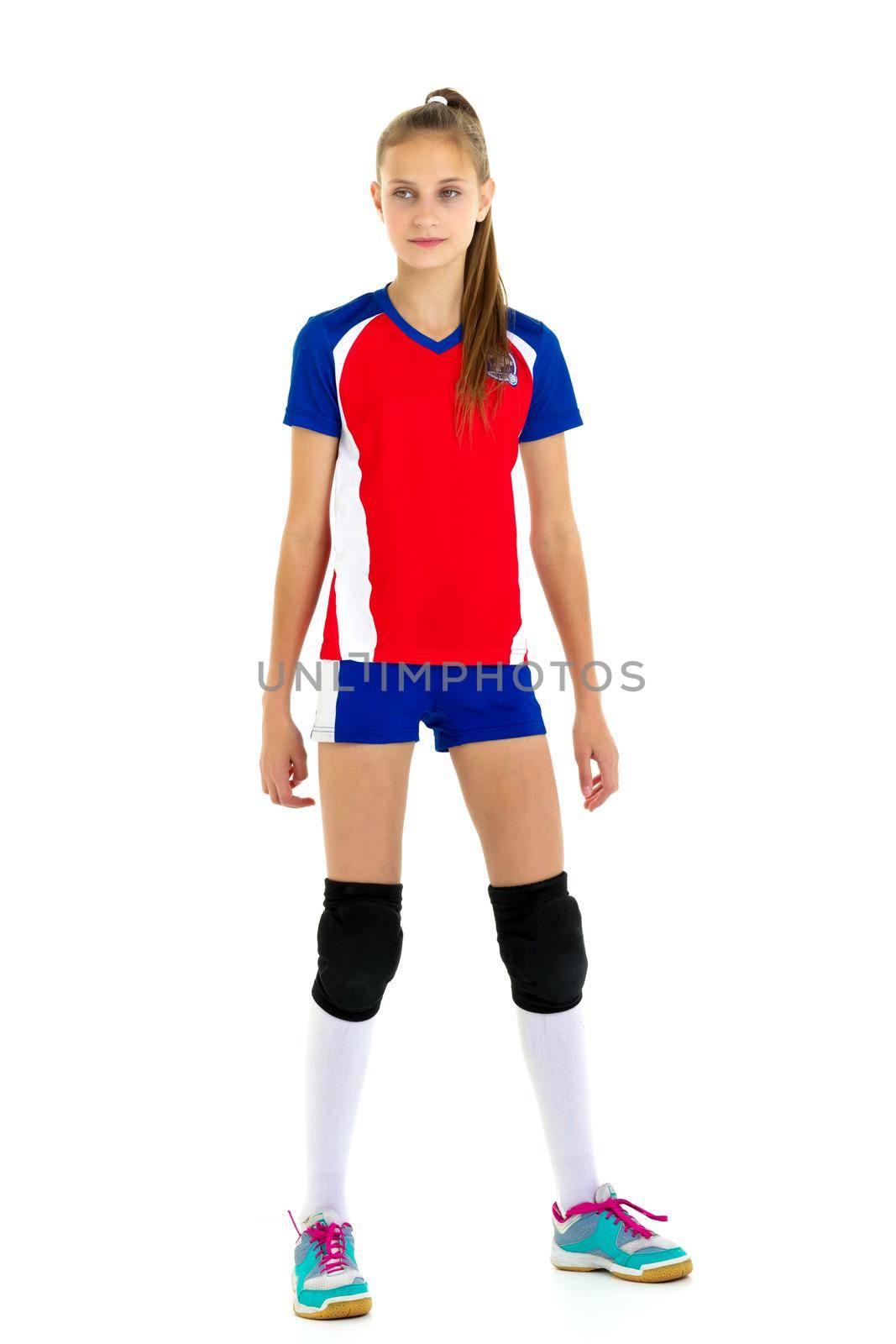 Full length shot of girl volleyball player. Pretty teenage girl in sports uniform, knee pads and sneakers standing on isolated white background. Healthy lifestyle, training, fitness concept