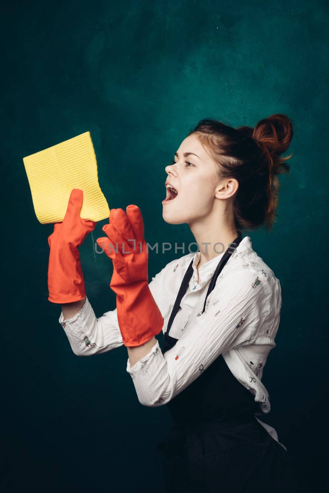 woman with rubber gloves in apron cleaning housework. High quality photo