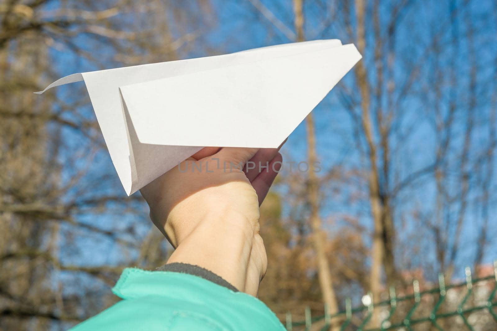 Abstract paper plane, in hand, blue sky, sun spring background