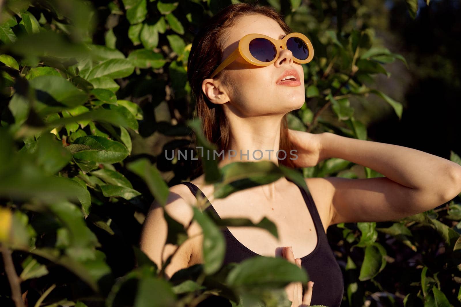 cheerful woman wearing sunglasses green leaves nature summer posing by Vichizh