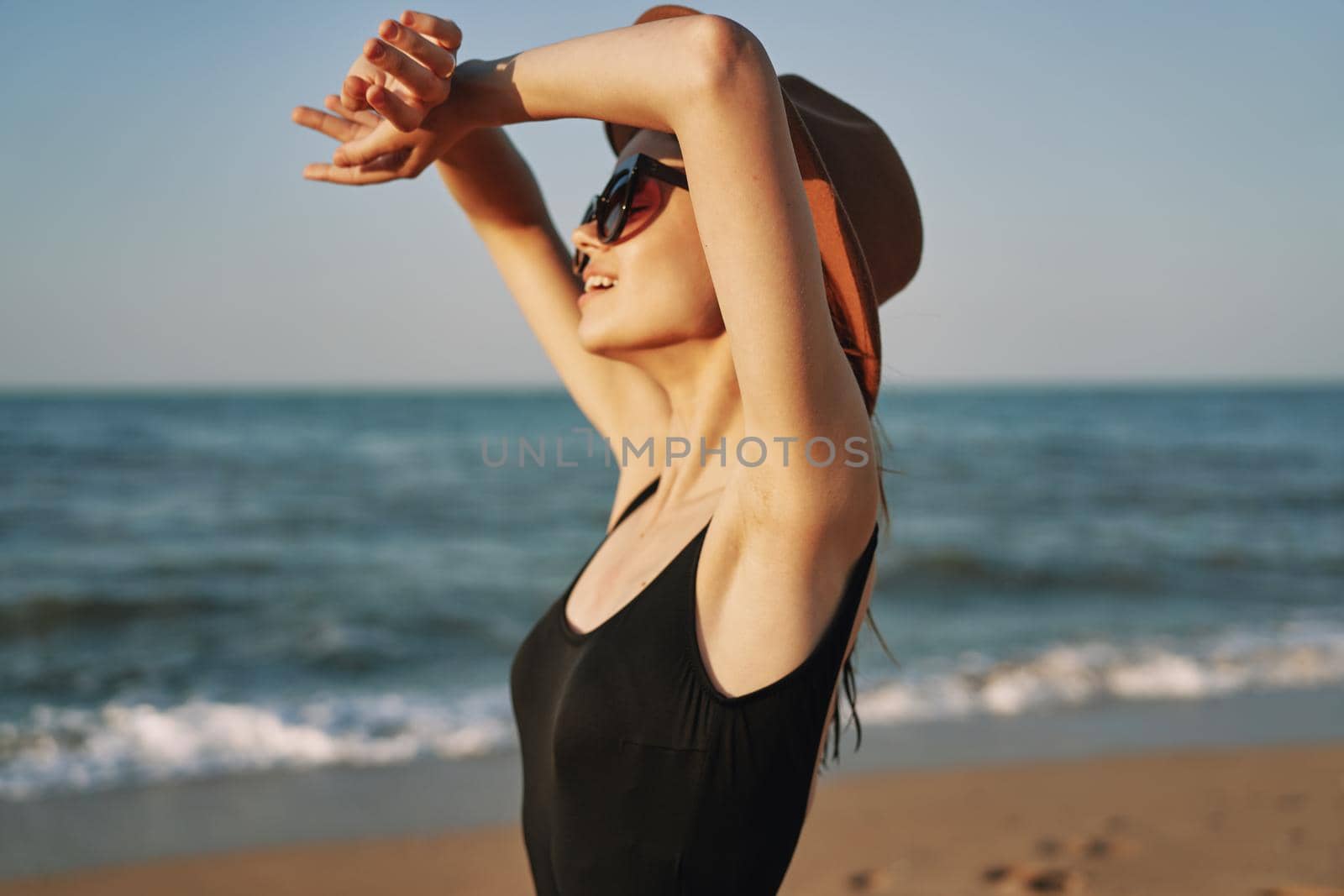 woman in a hat sunglasses by the ocean travel sun. High quality photo