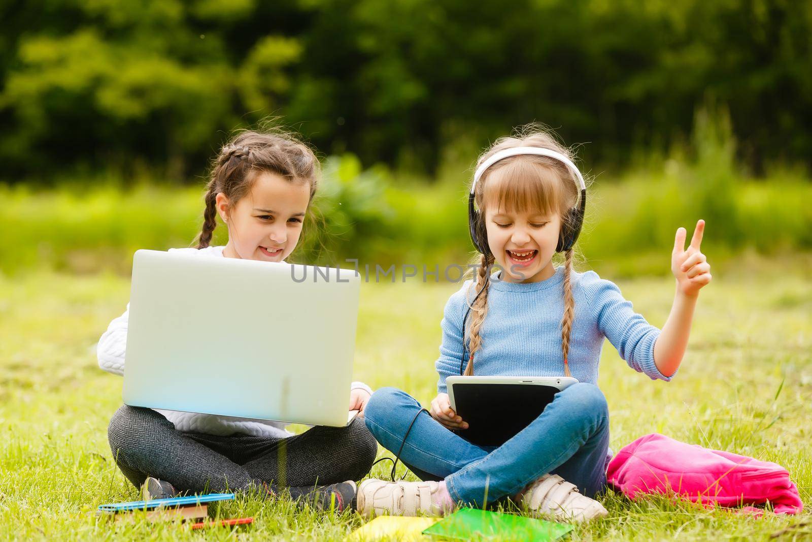 Two teenage girl. Summer in nature. They are sitting on the grass. Communicate with each other. He talks intimate conversation. Best friends. Privacy from adults. by Andelov13