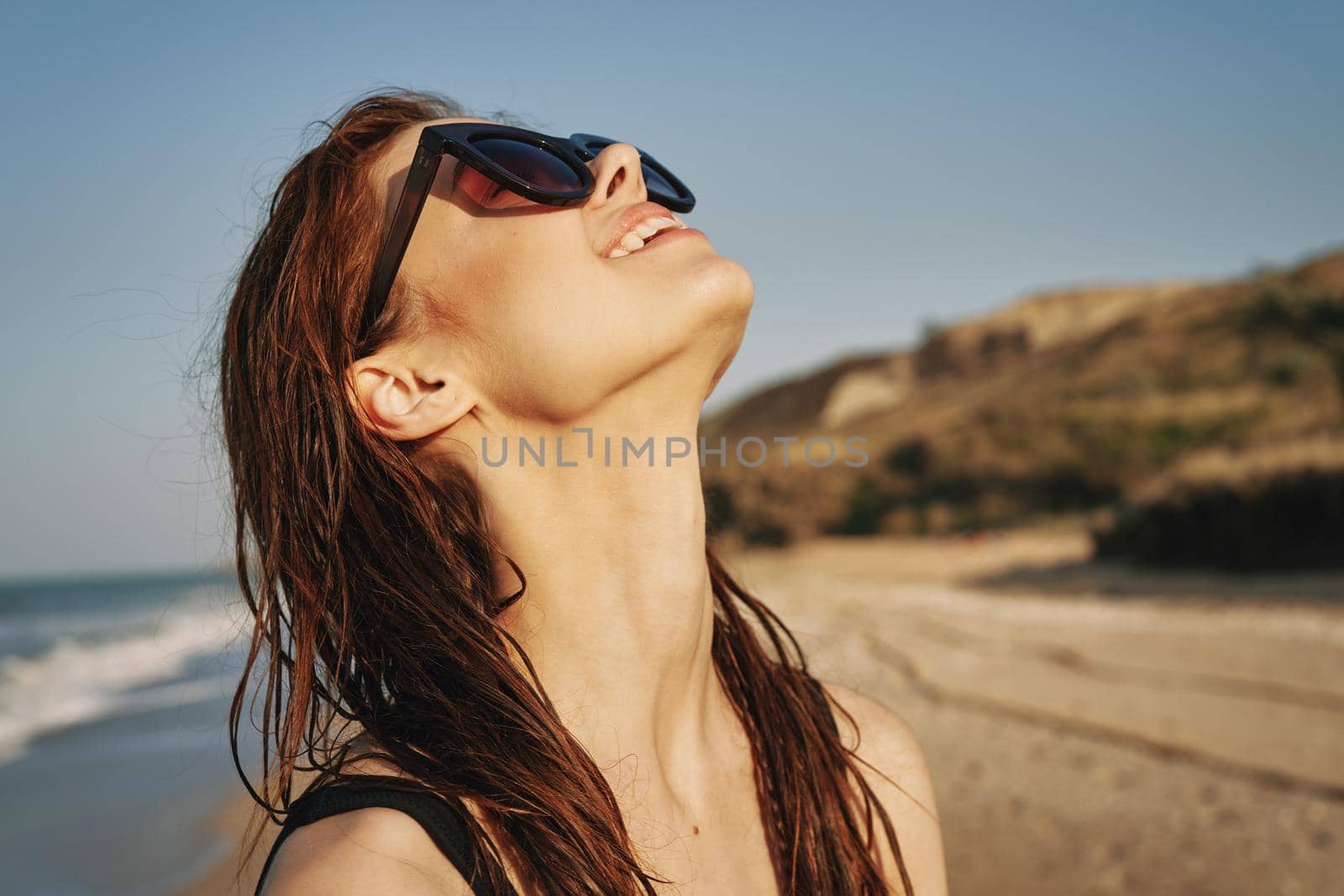 cheerful woman in sunglasses in a swimsuit on the beach sun island. High quality photo