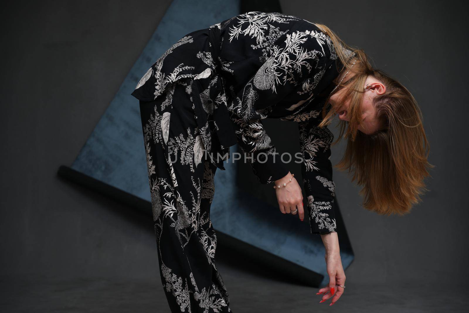 portrait high resolution photo girl model posing bending over dark background in studio