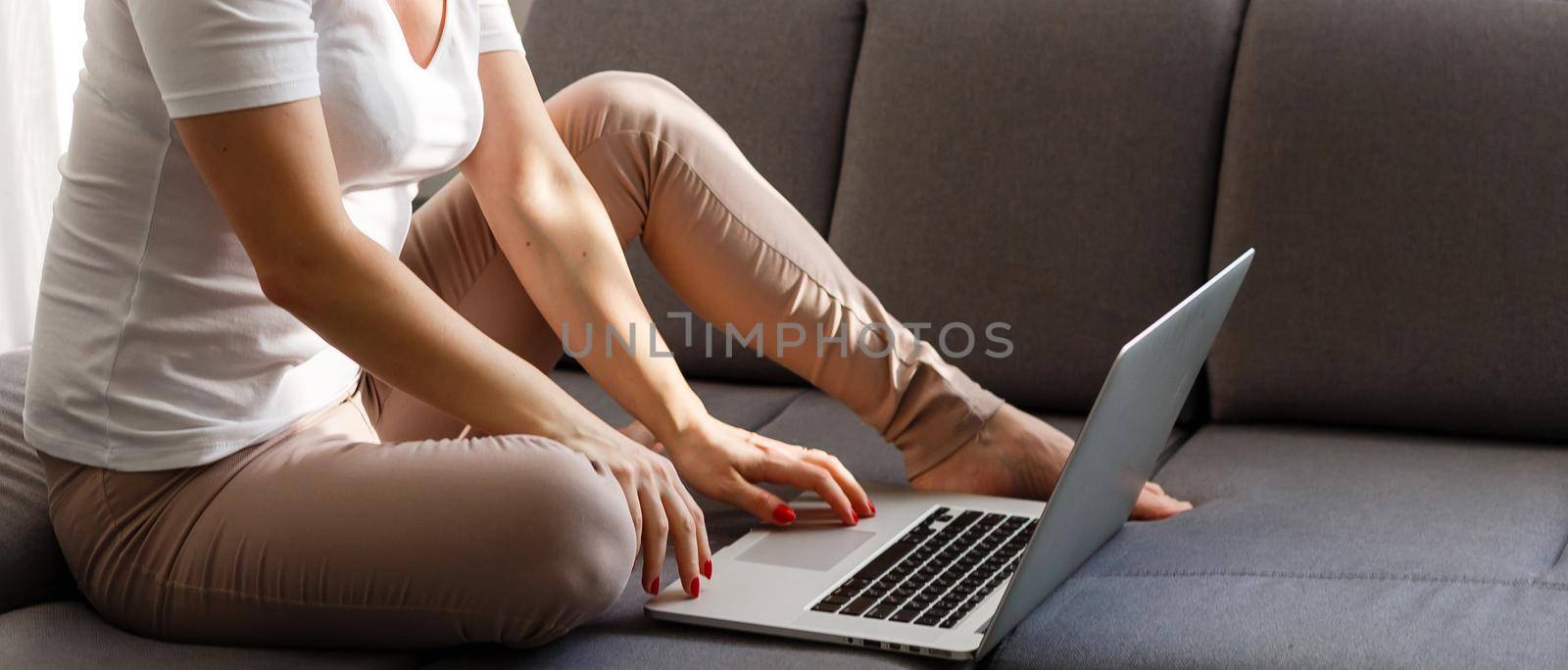 A smiling woman in front of her laptop at home by Andelov13