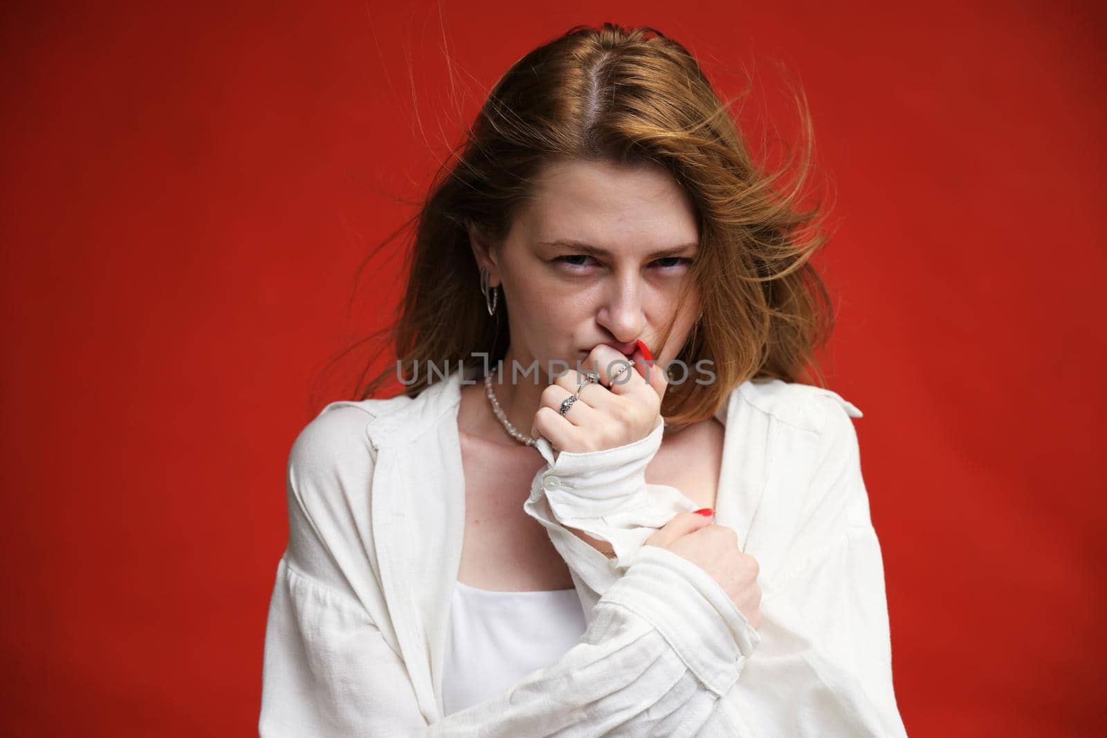 Portrait of Caucasian model showing discontent on red background