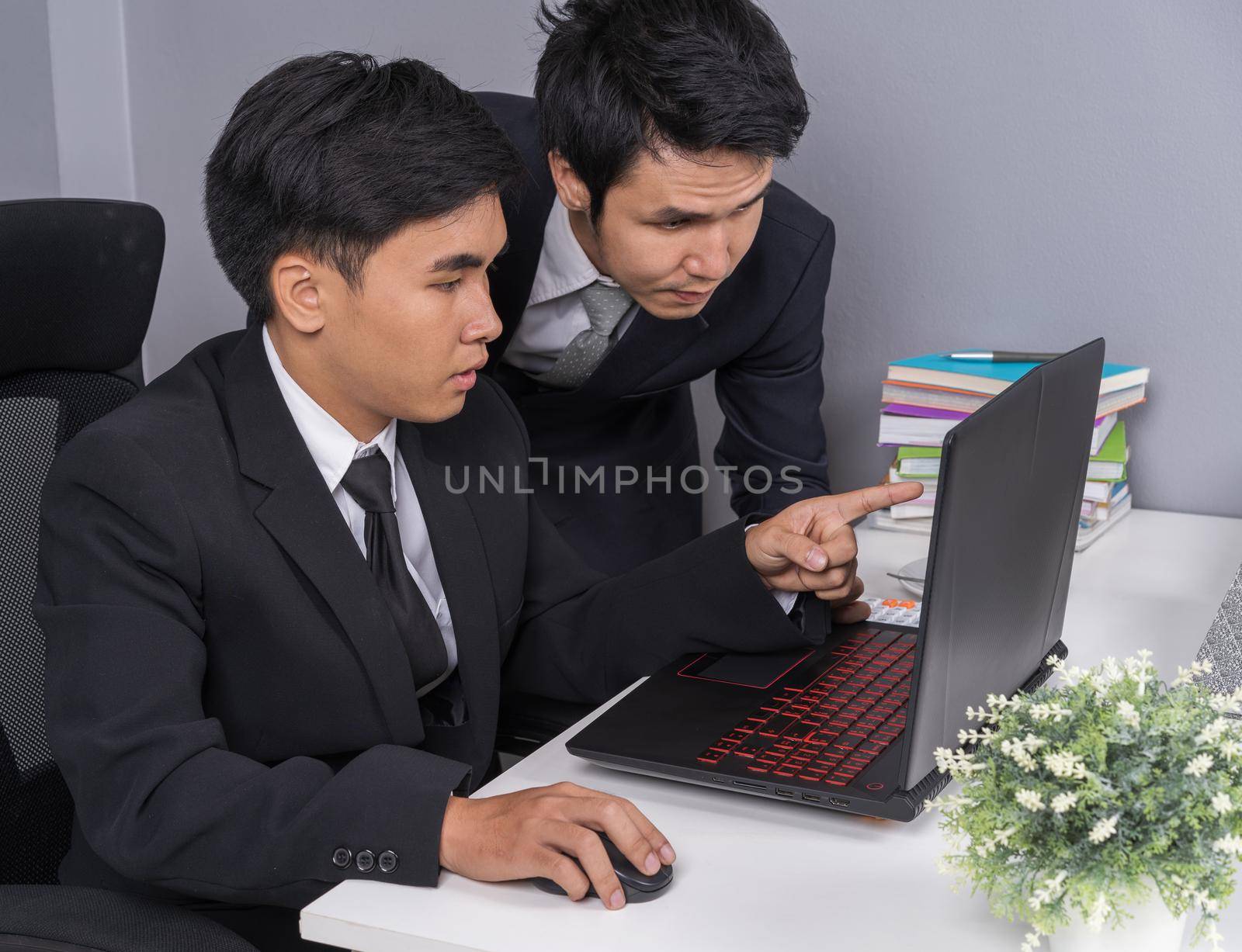 two business man using laptop and discussing project by geargodz