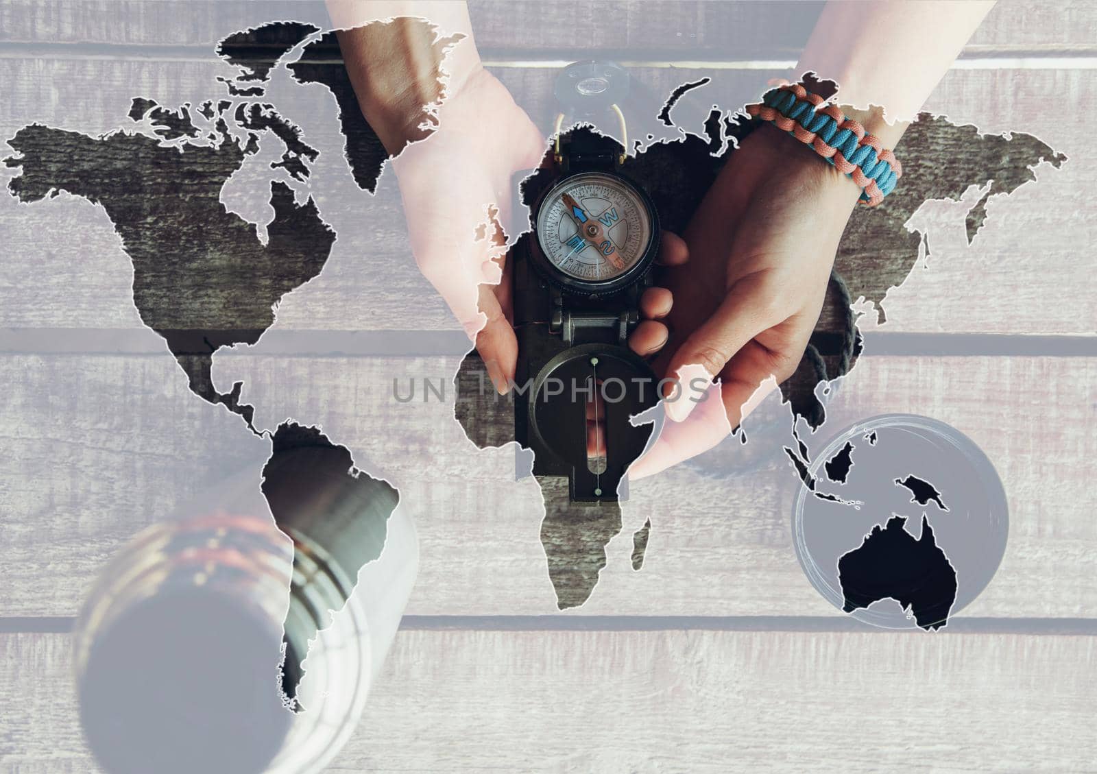 Double exposure of female hands holding compass with map of world, concept of travel.