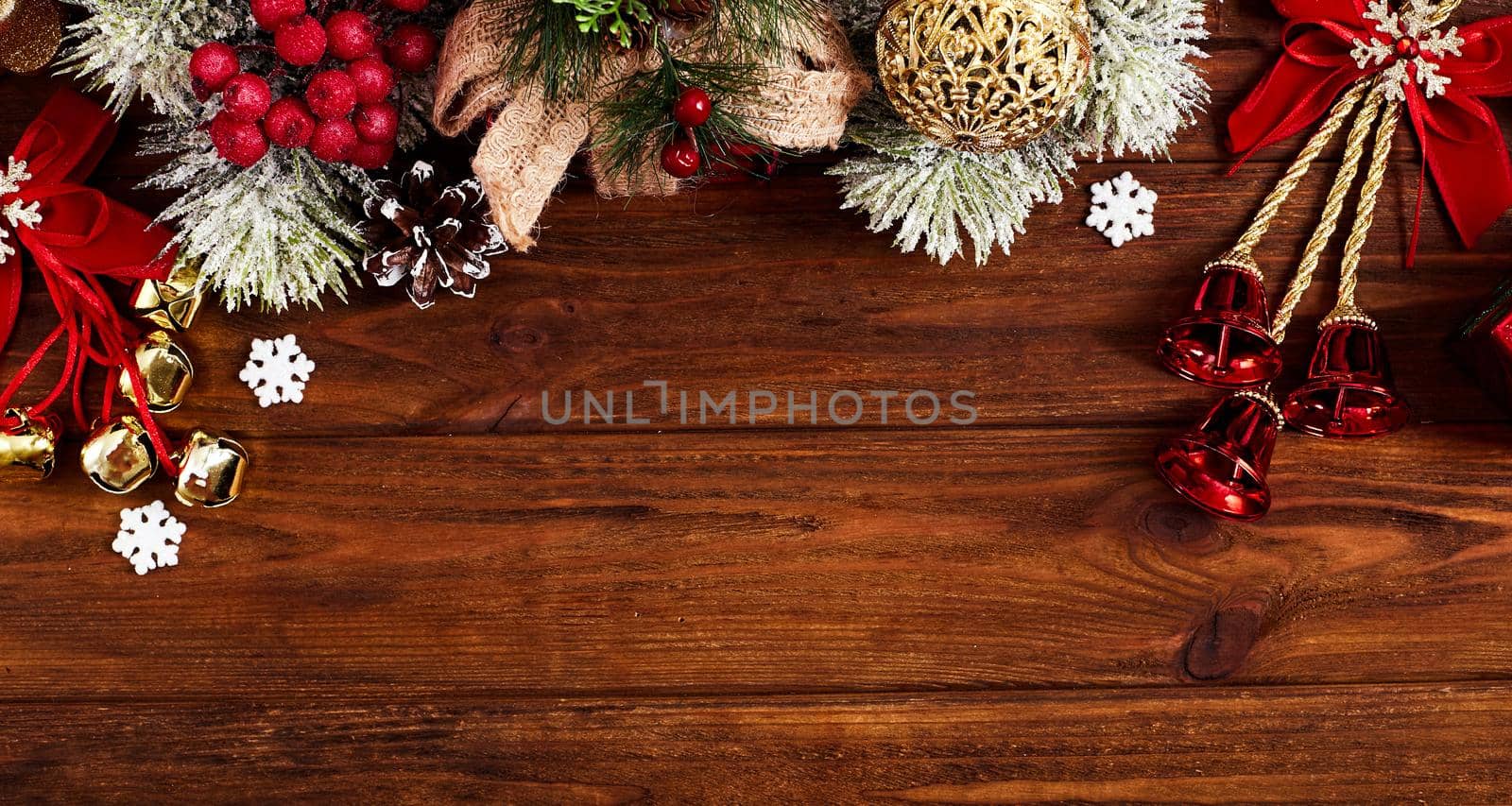 Christmas composition of spruce branches, gift, cinnamon, anise and confetti stars on rustic wooden background. Flat plan, top view