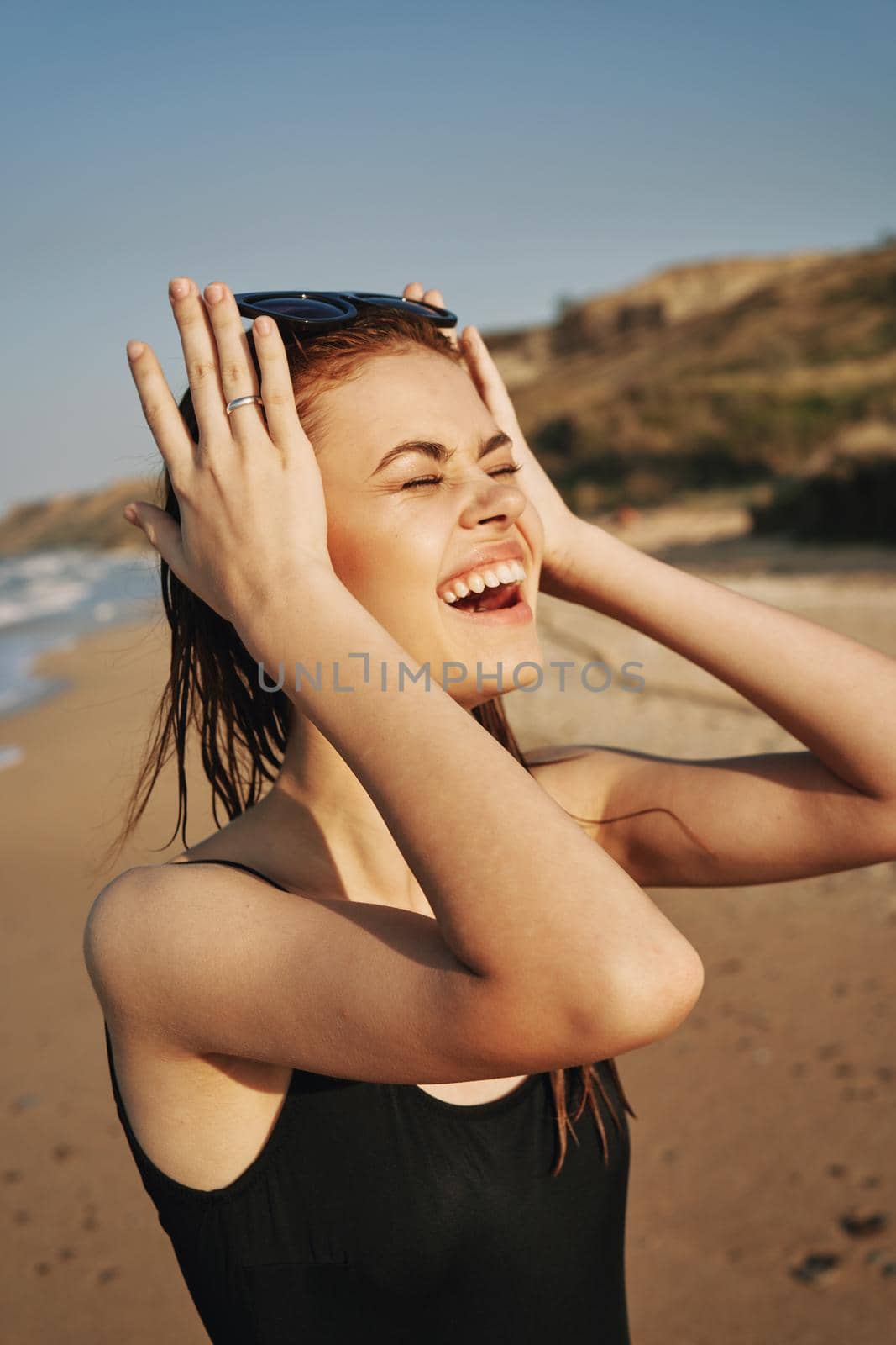 cheerful woman sunglasses posing black swimsuit island. High quality photo