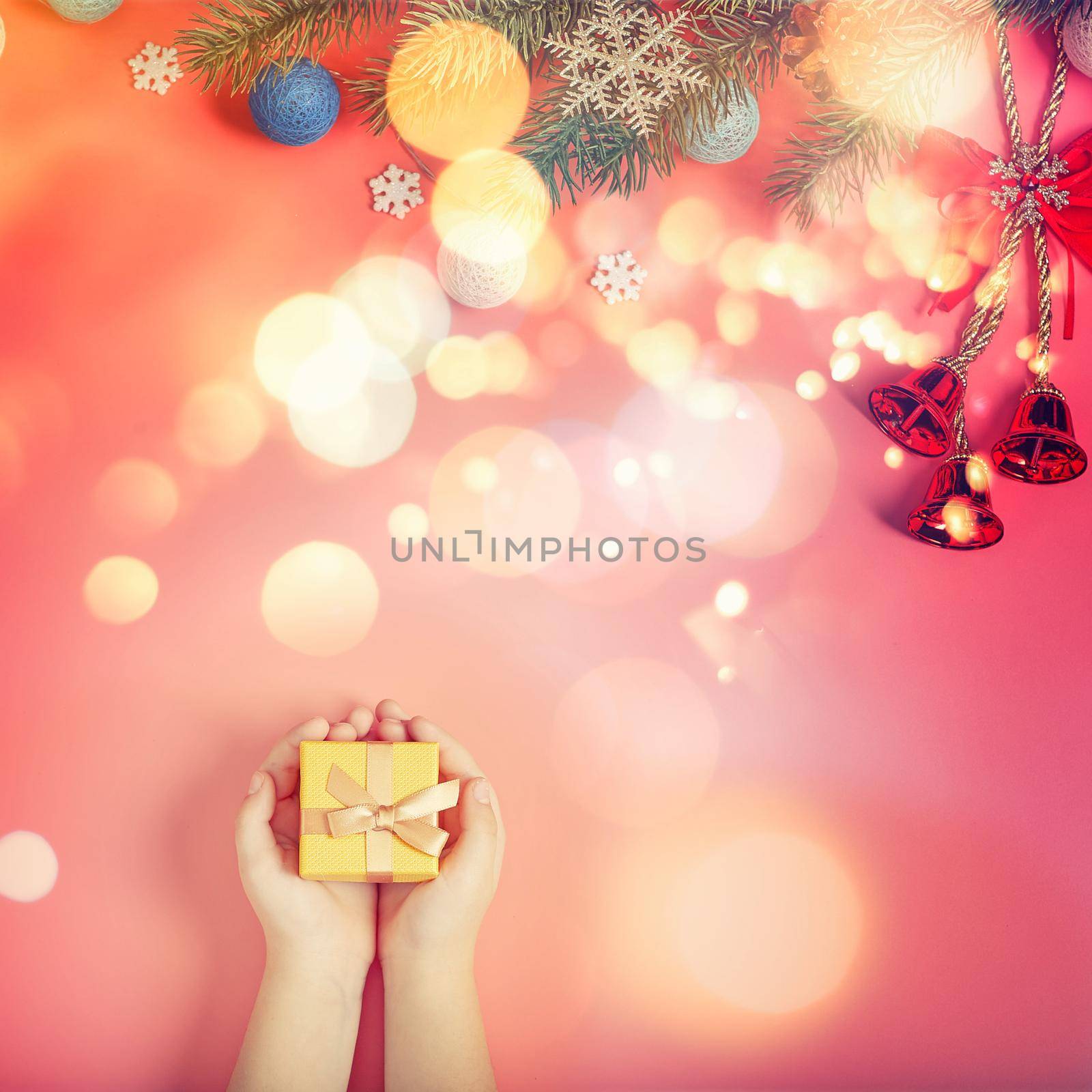 The child is holding a New Year's gift on a pink background with New Year's decorations. by Maximusnd