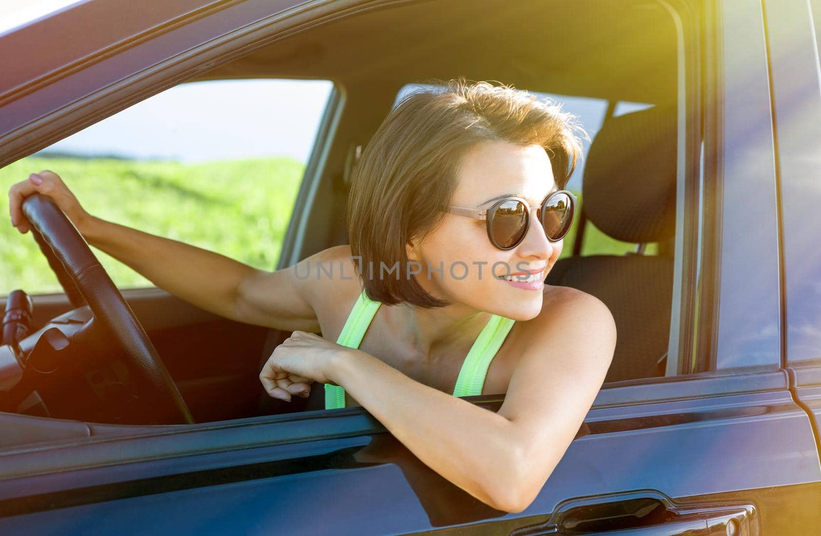 Adult attractive happy woman sitting in car - summer portrait outdoor