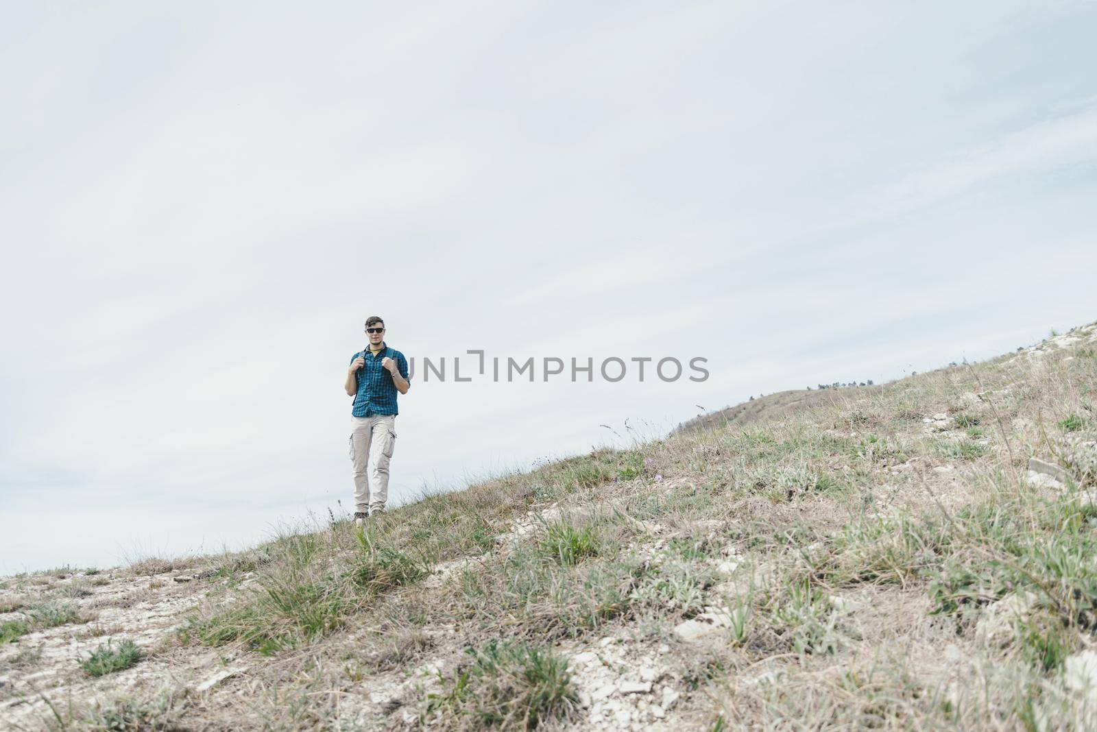 Explorer young man with backpack walking outdoor.