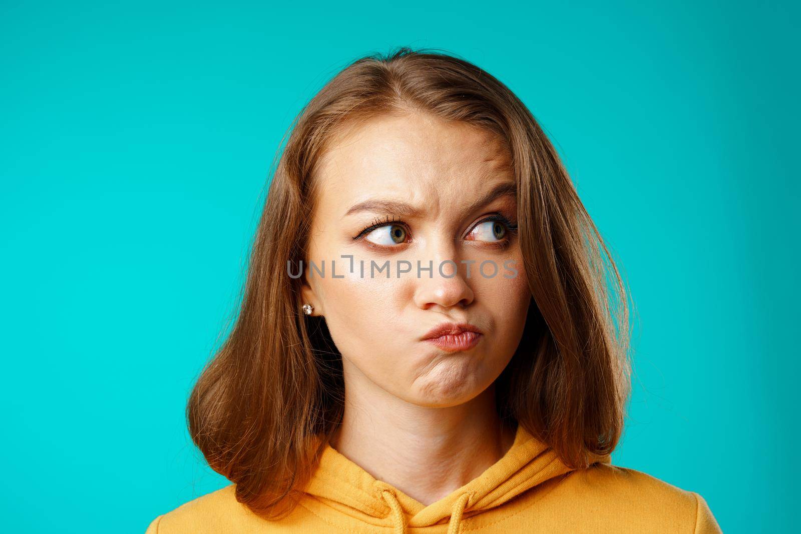 Studio portrait of beautiful young casual woman thinking about something