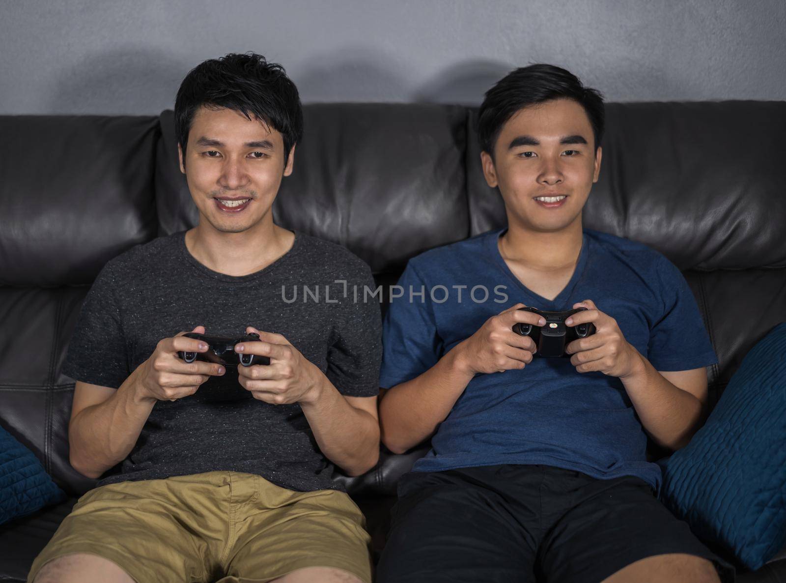 two happy man playing video games at night