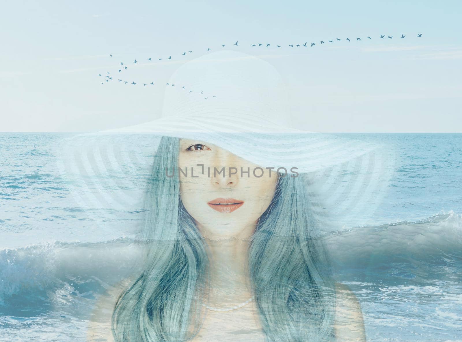 Double exposure portrait of beautiful young woman with blue hair combined with image of seascape.