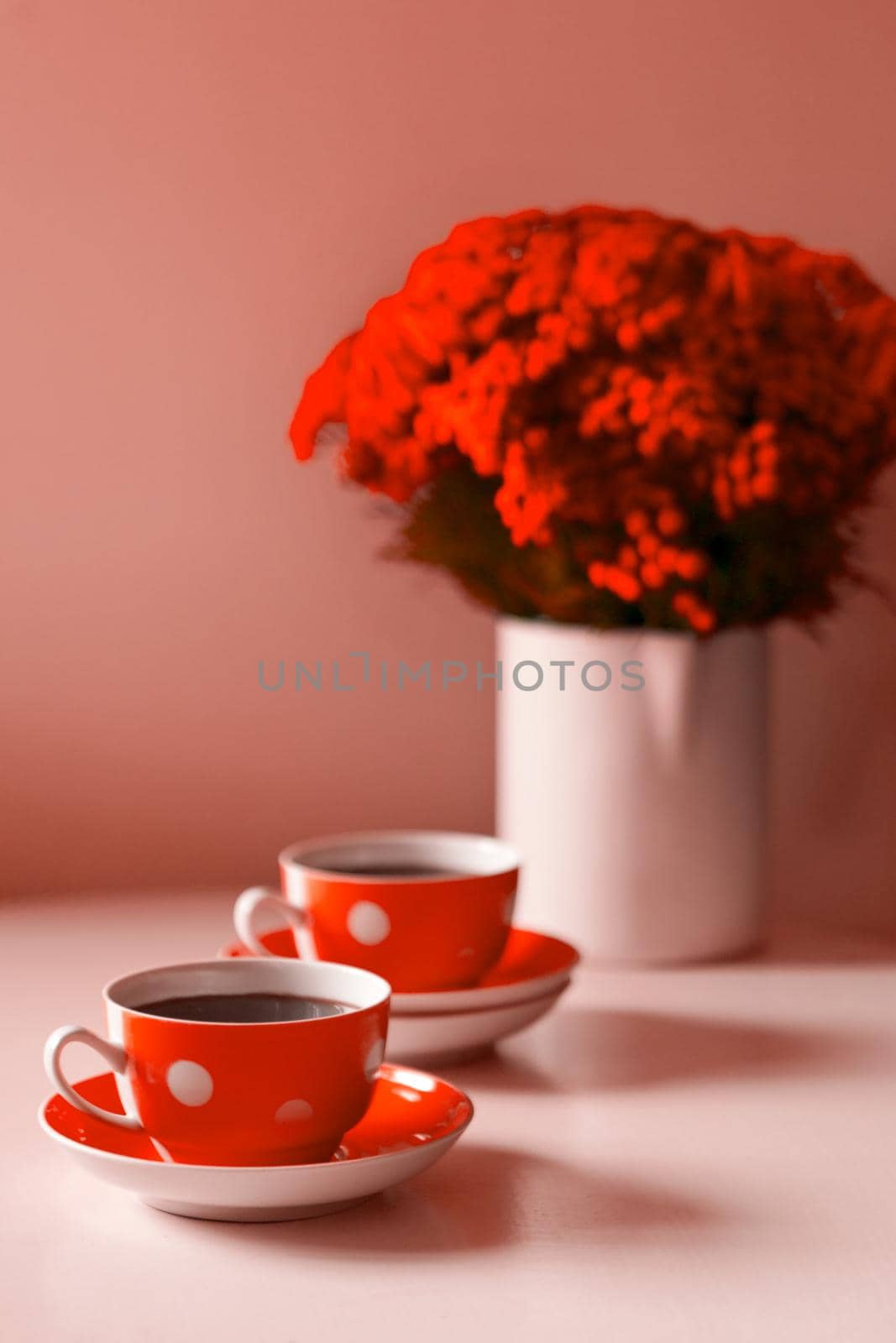 red flowers bouquet on the table - Two red coffee cups on white background, coffee break and caffeine addiction concept. vintage design and retro style