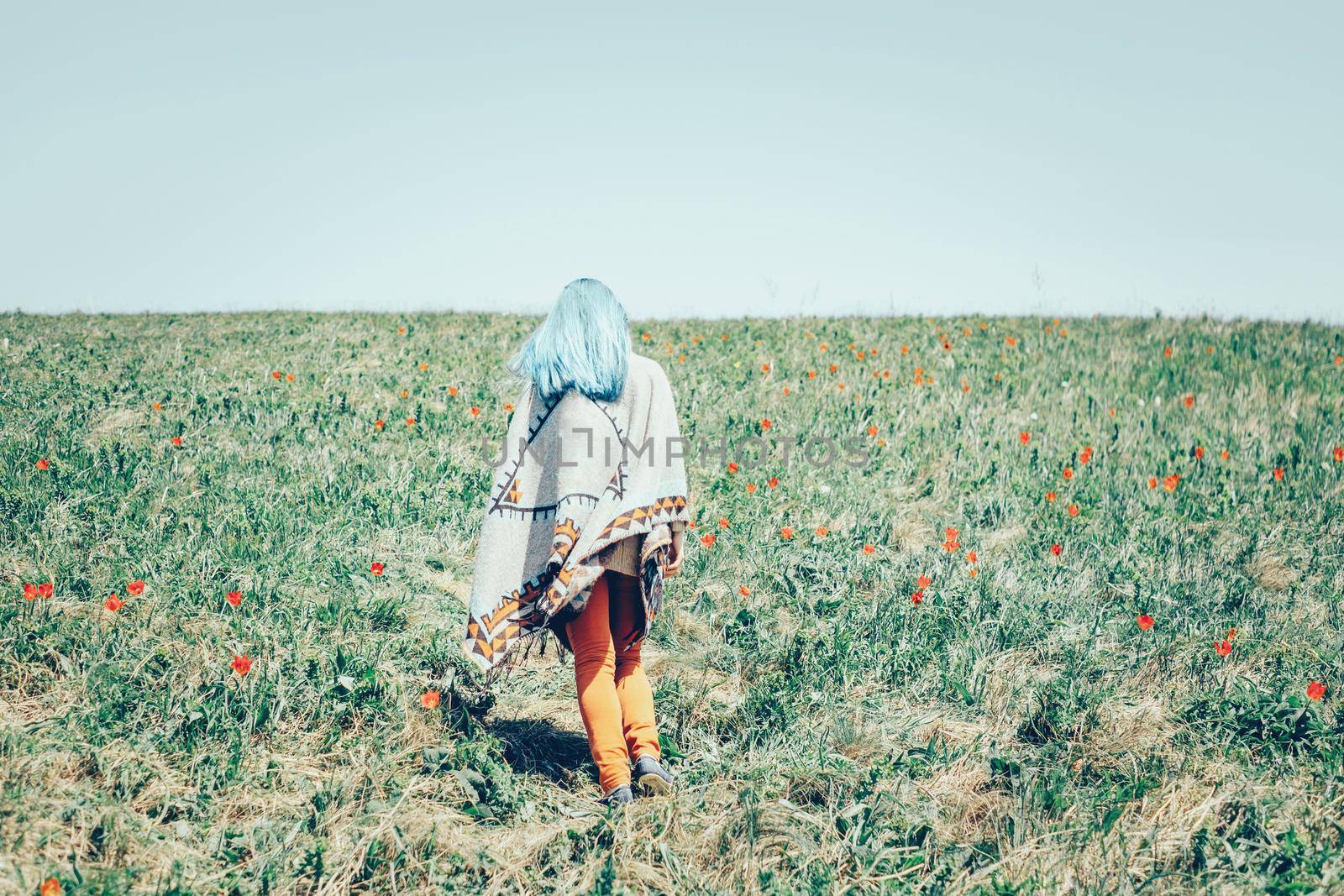 Woman walking in flower field. by alexAleksei