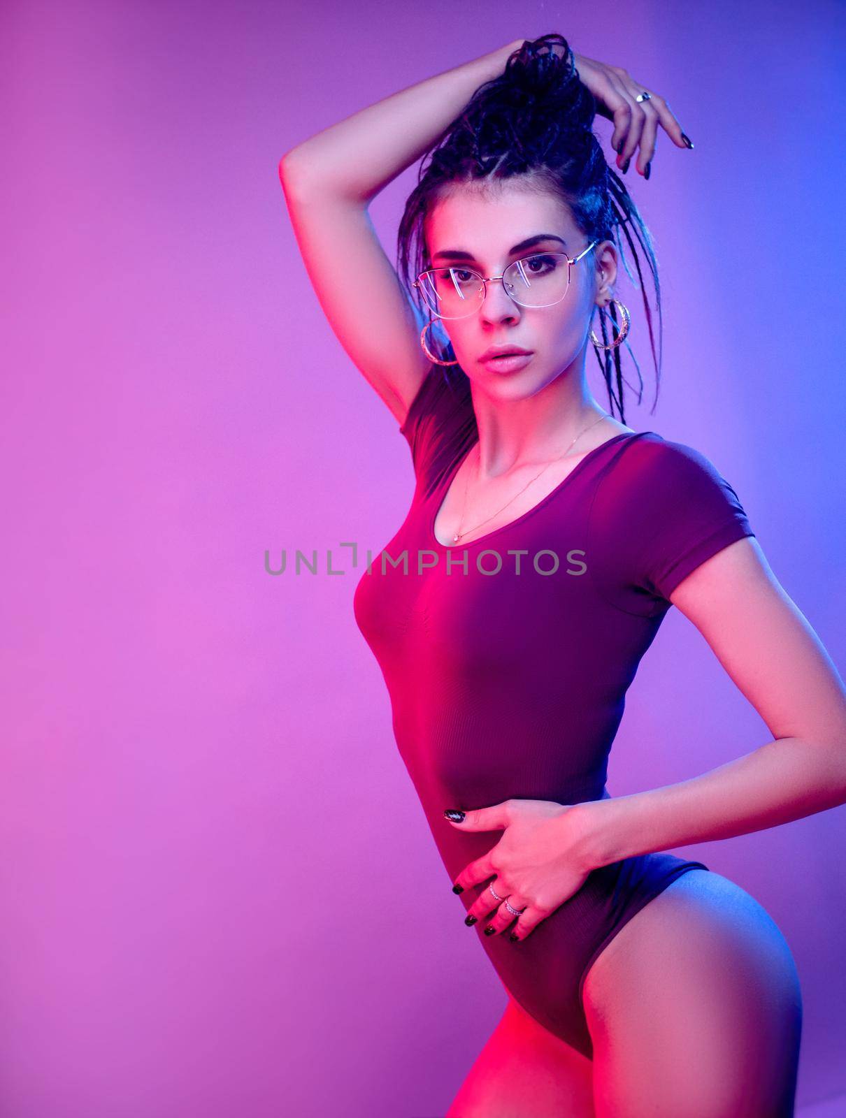 the slender girl on a white background of neon color posing in a bodysuit