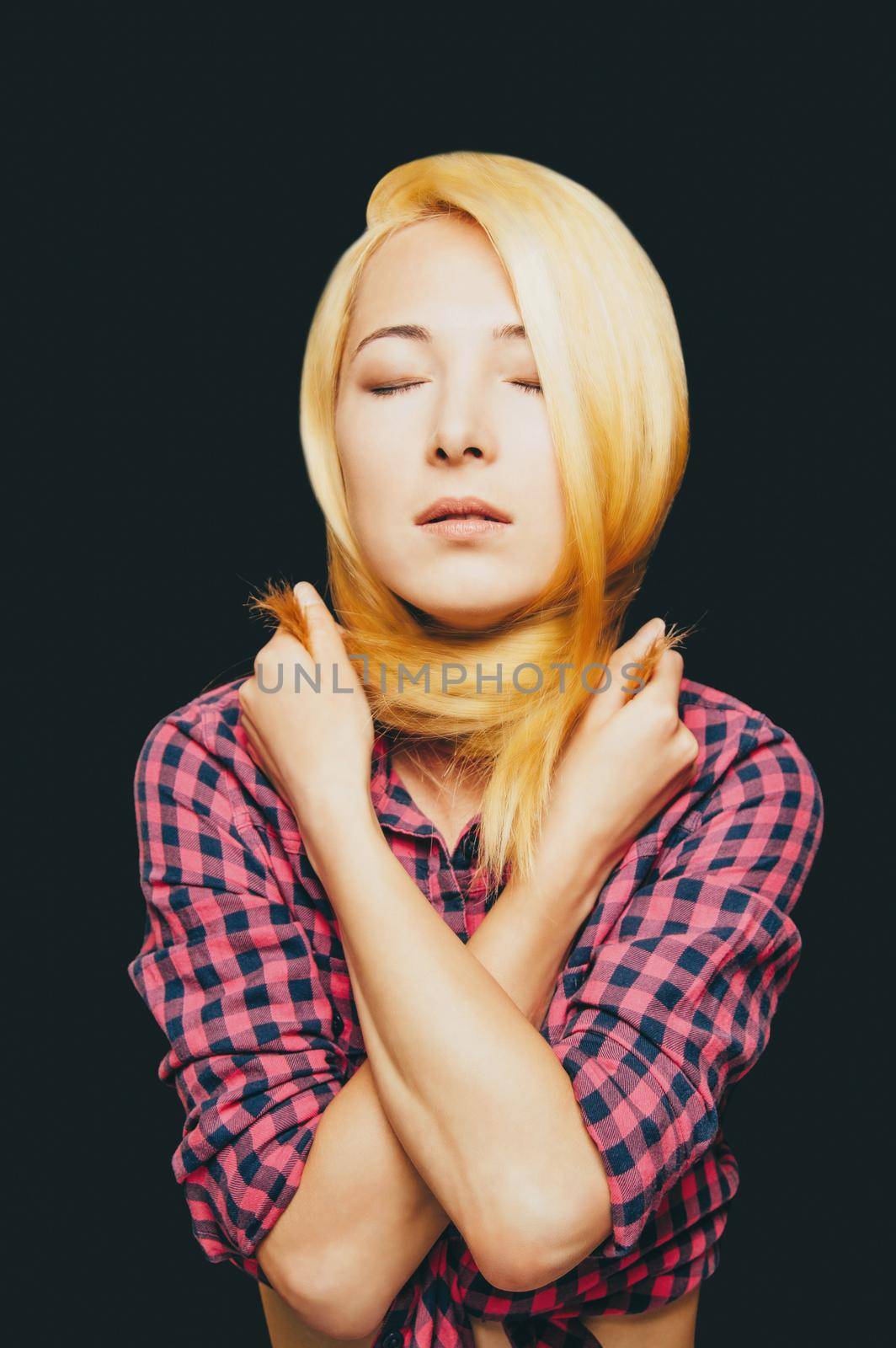 Fashionable blonde young woman wearing in plaid shirt. Beauty and hairstyle concept.