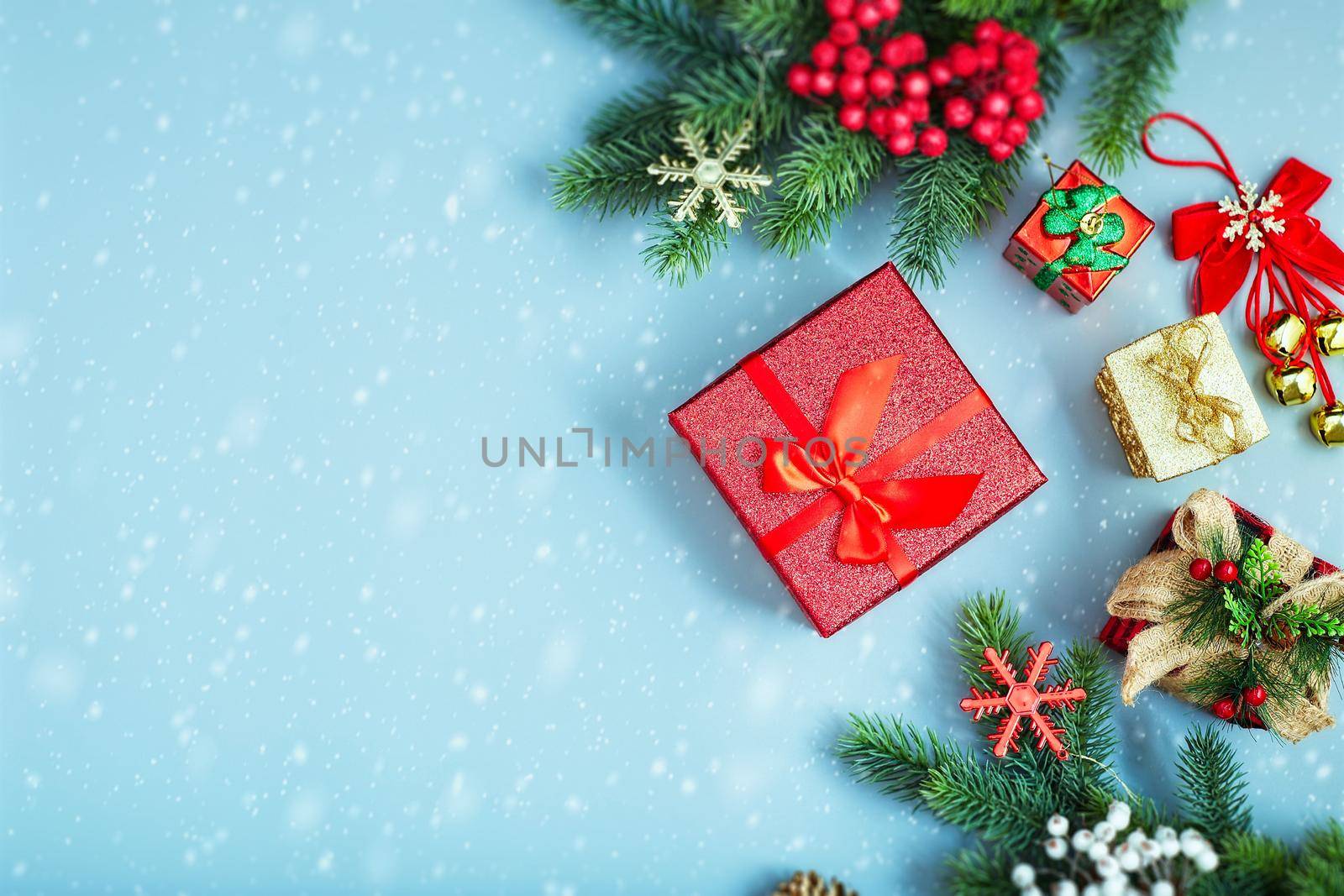 Frame of twigs christmas tree, brown natural pine cones and red berries on snow with space for text. Top view, flat lay