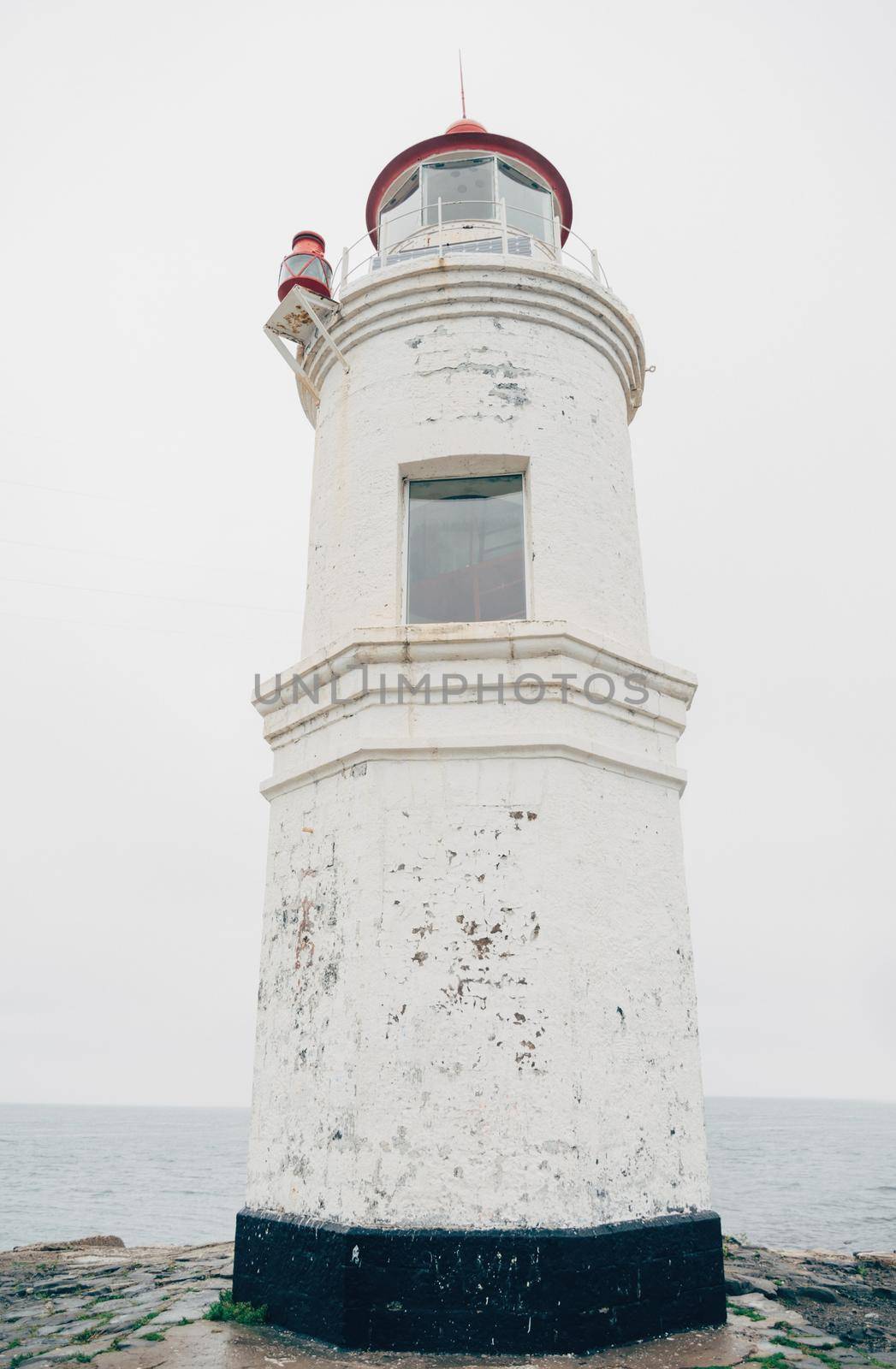 Old lighthouse on coastline, close-up.