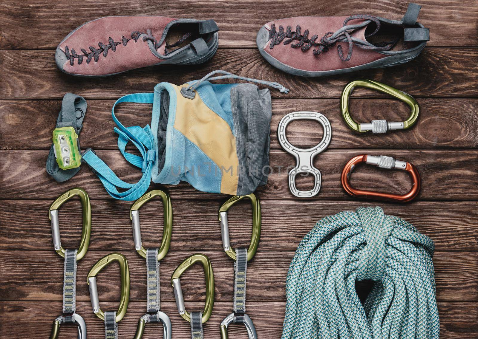 Equipment for climbing sport on wooden background, top view.