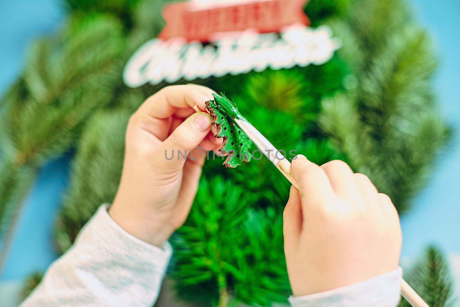 A girl draws a Christmas tree, preparing for the New Year 2022. Merry Christmas and happy new year concept