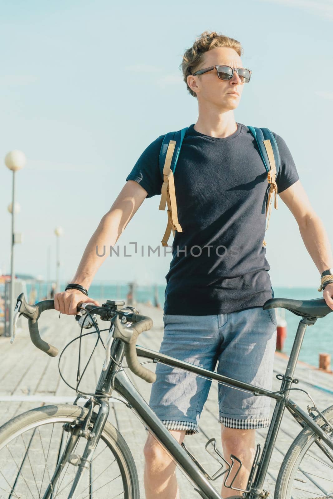 Cyclist standing on the pier. by alexAleksei