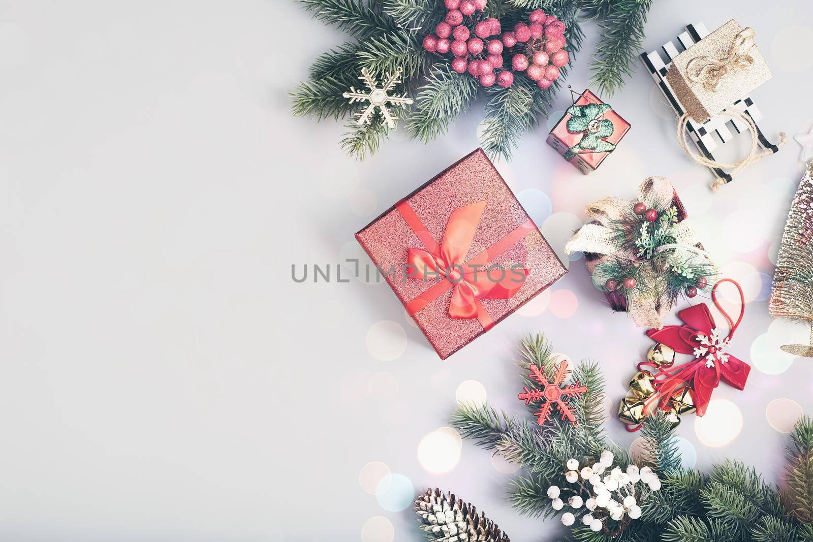 Frame of twigs christmas tree, brown natural pine cones and red berries on snow with space for text. Top view, flat lay